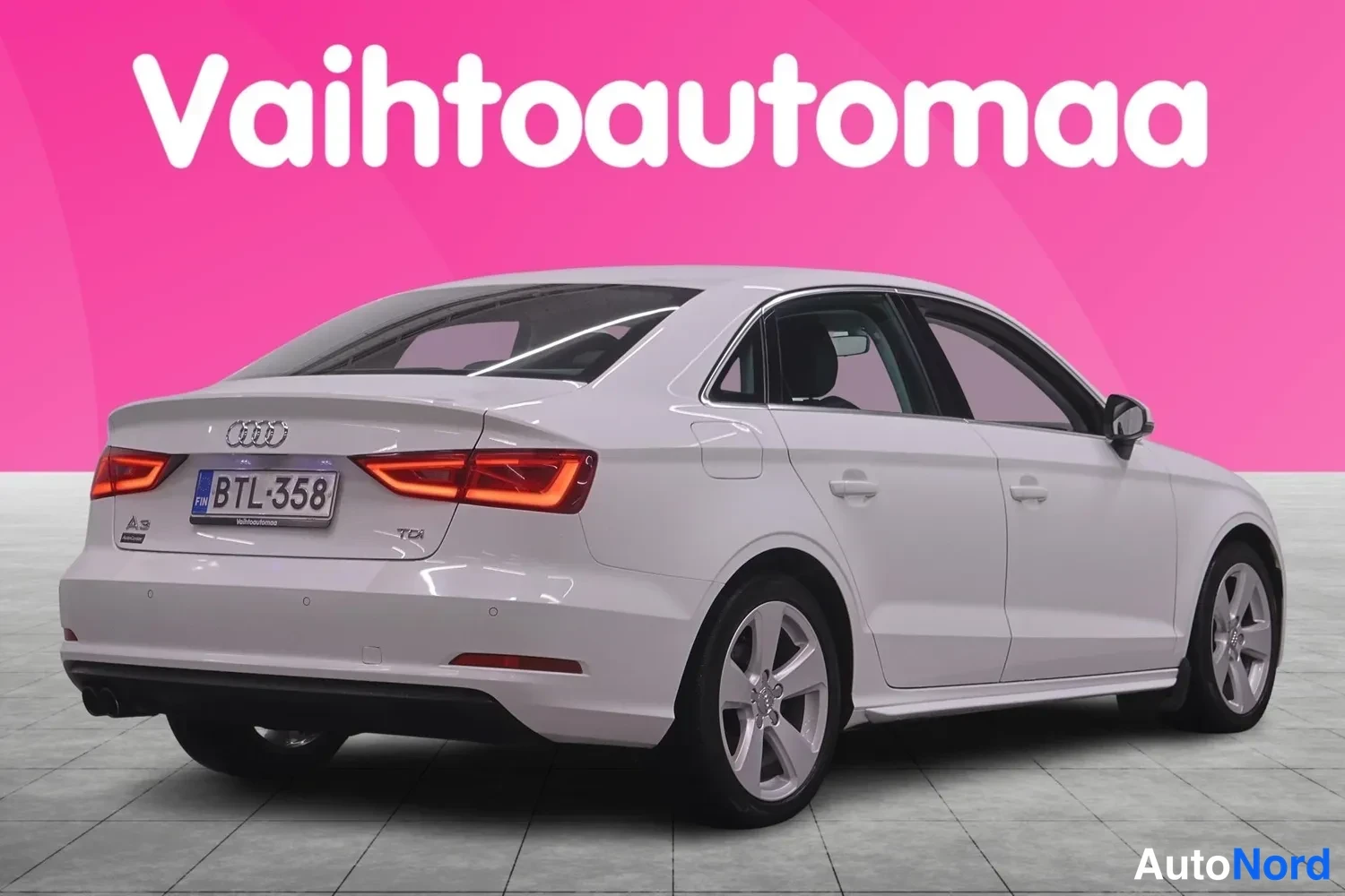 Takaviisto: Taakse kääntynyt valkoinen Audi A3 -seis, jossa on takavalot, rekisterinumero, ja TDI-logo. Takapeltiä ja oikeaa kylkeä näkyy.