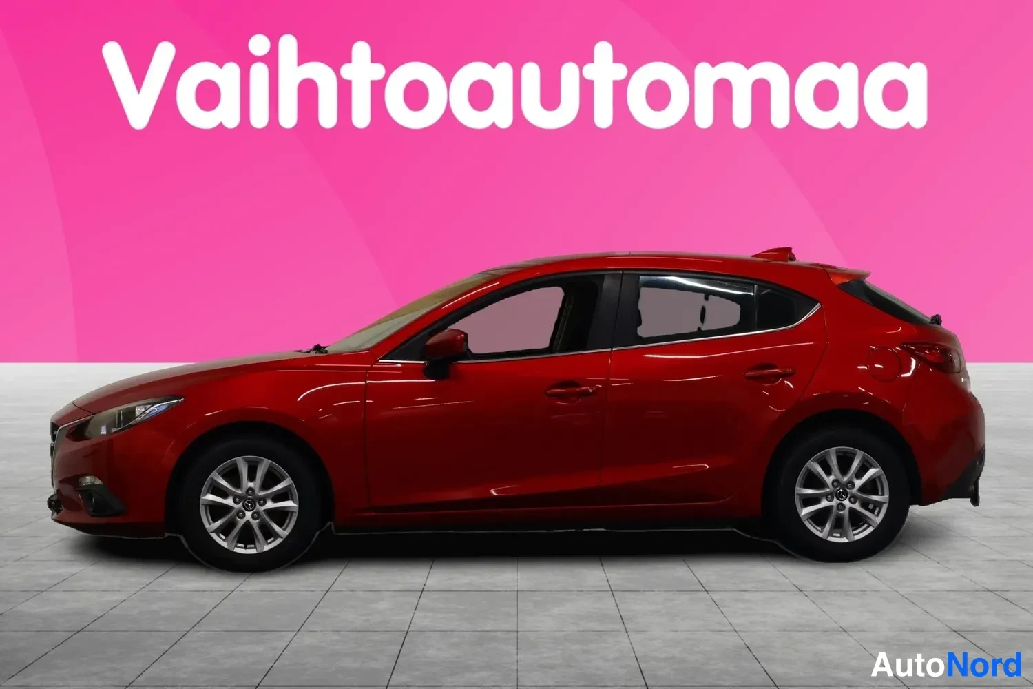 Etuviisto, nokka vasemmalle: Punaisen Mazda 3 -farmariauto etuosaltaan vasemmalta