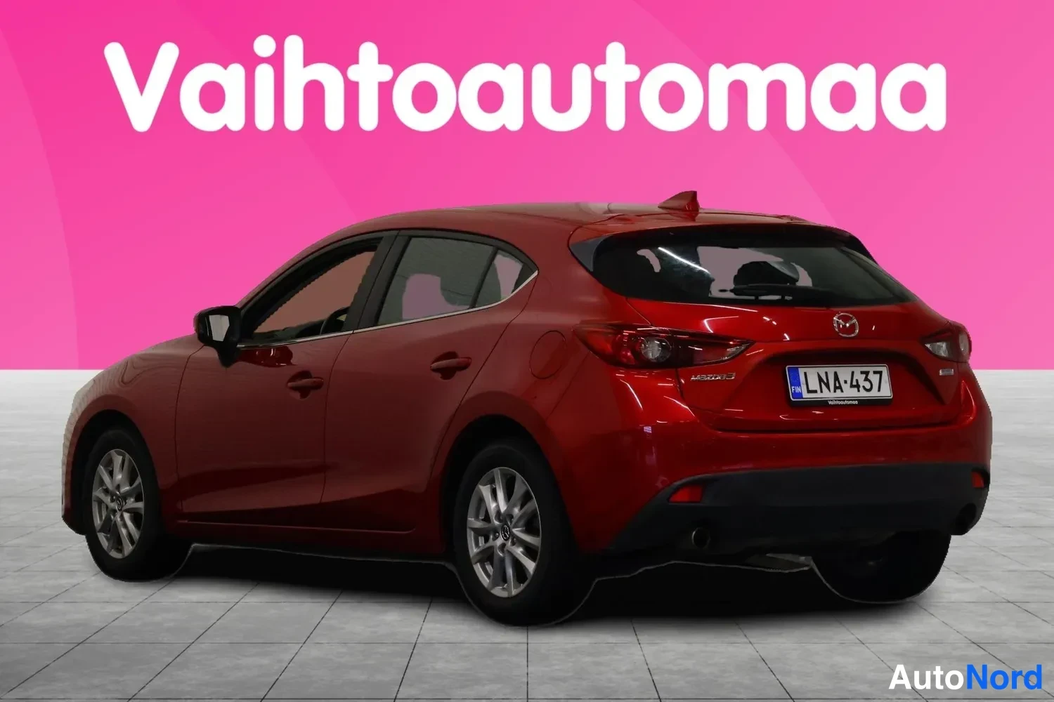 Takaviisto: Punaisen Mazda 3 -auto takapuoli ja vasen kylki