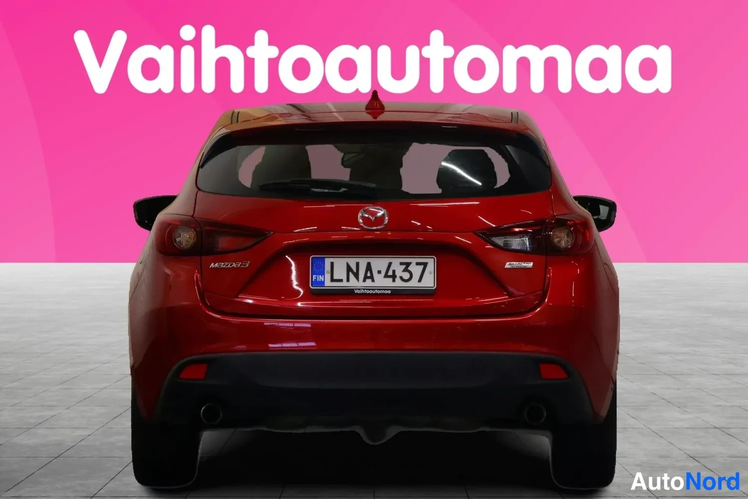 Takaa: Punaisen Mazda 3 -auto suoraan takaa, rekisterikilpi