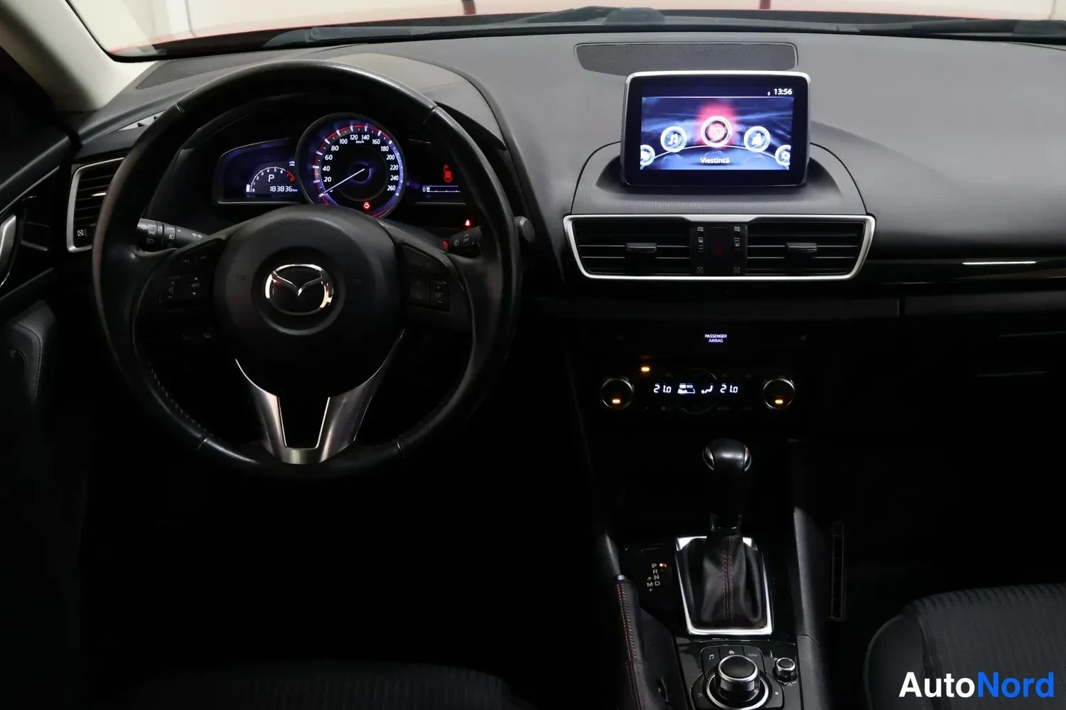 Muu: Ohjaamo eteenpäin: Mazda-ohjauspyörä, mittaristo, keskikonsolin automaattivaihteen valitsin ja infotainment-näyttö.