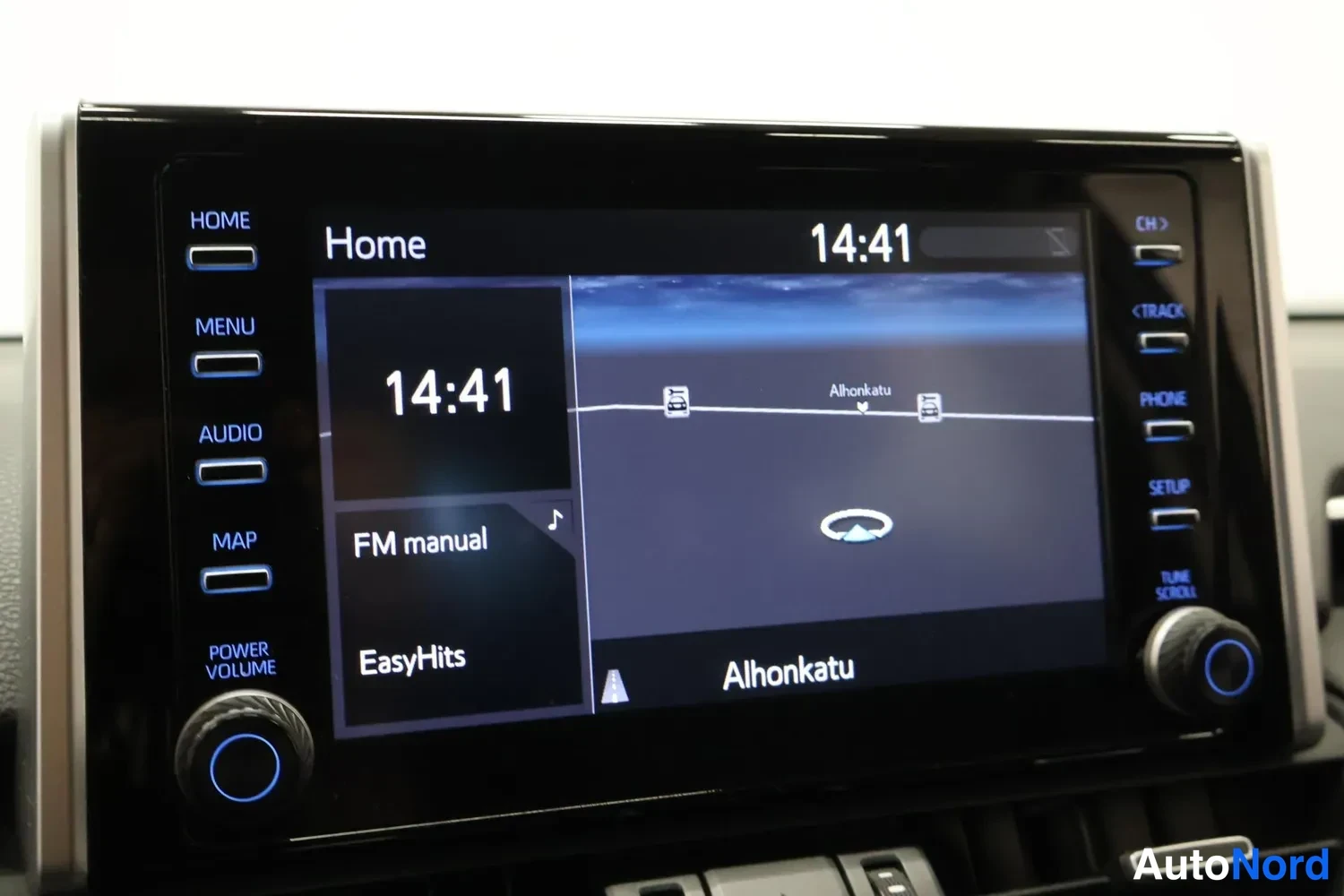 Yksityiskohta: Auton radio-multimediajestelmän kosketusnäyttö Home-näkymässä, kello 14:41, ruudulla FM manual ja EasyHits sekä karttaan liittyvä Alhonkatu-teksti.