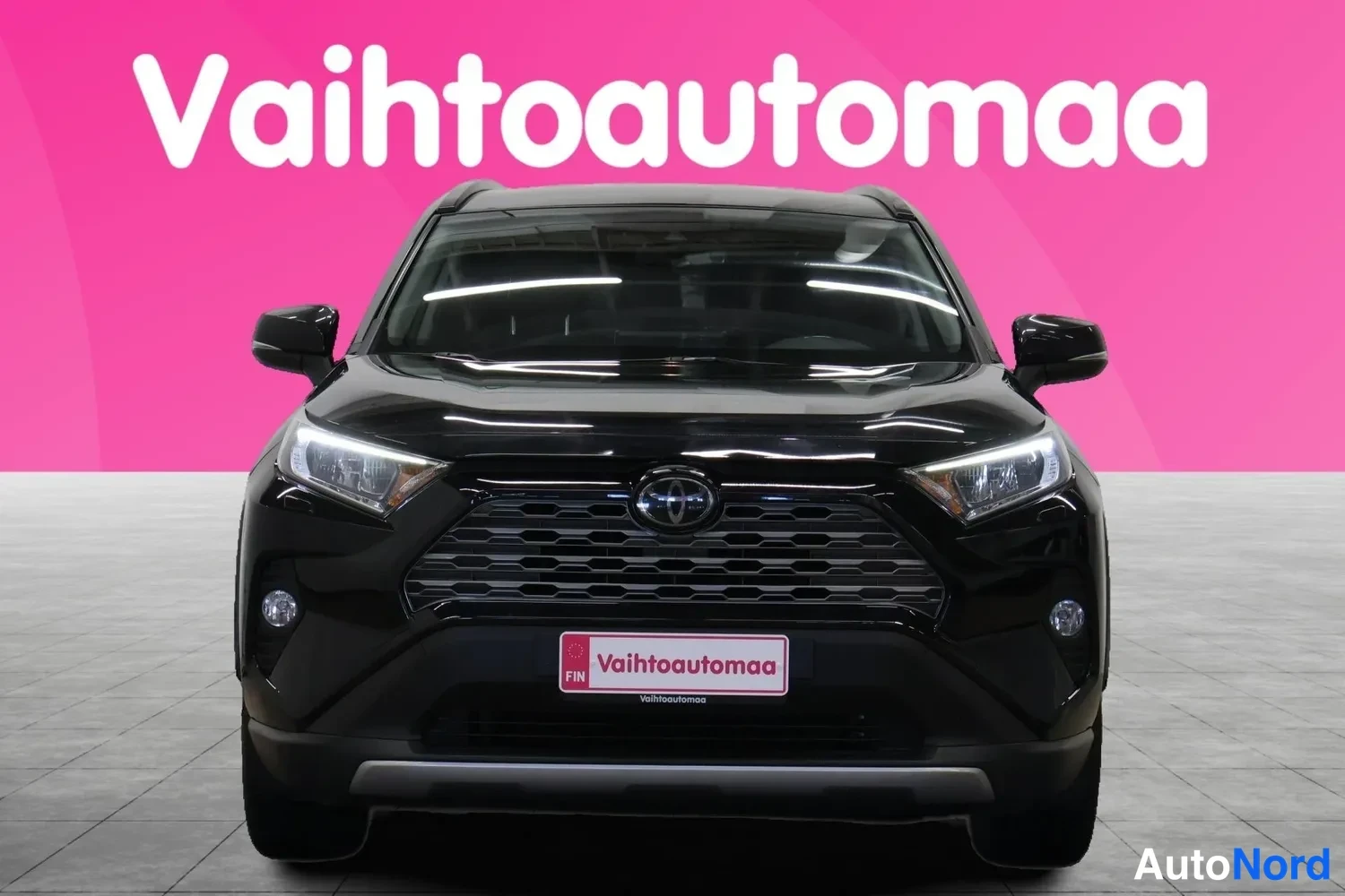 Edestä: Musta Toyota RAV4 -maasturi suoraan edestäpäin, etusäleikkö ja Toyota-merkki näkyvissä.