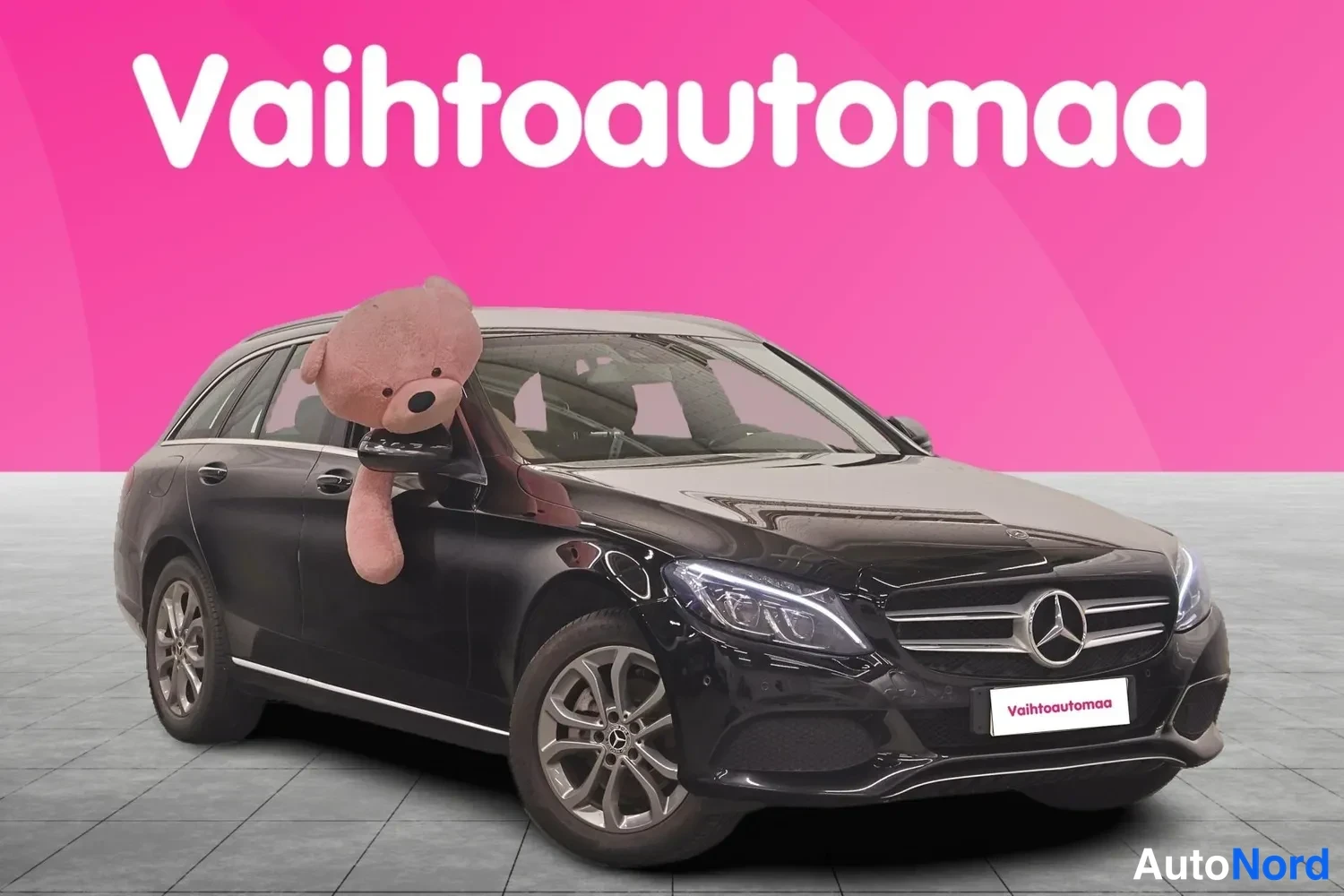 Etuviisto, nokka oikealle: Musta Mercedes-Benz C 200 -farmari etukulmasta oikealta, keula kuvan oikeassa reunassa.
