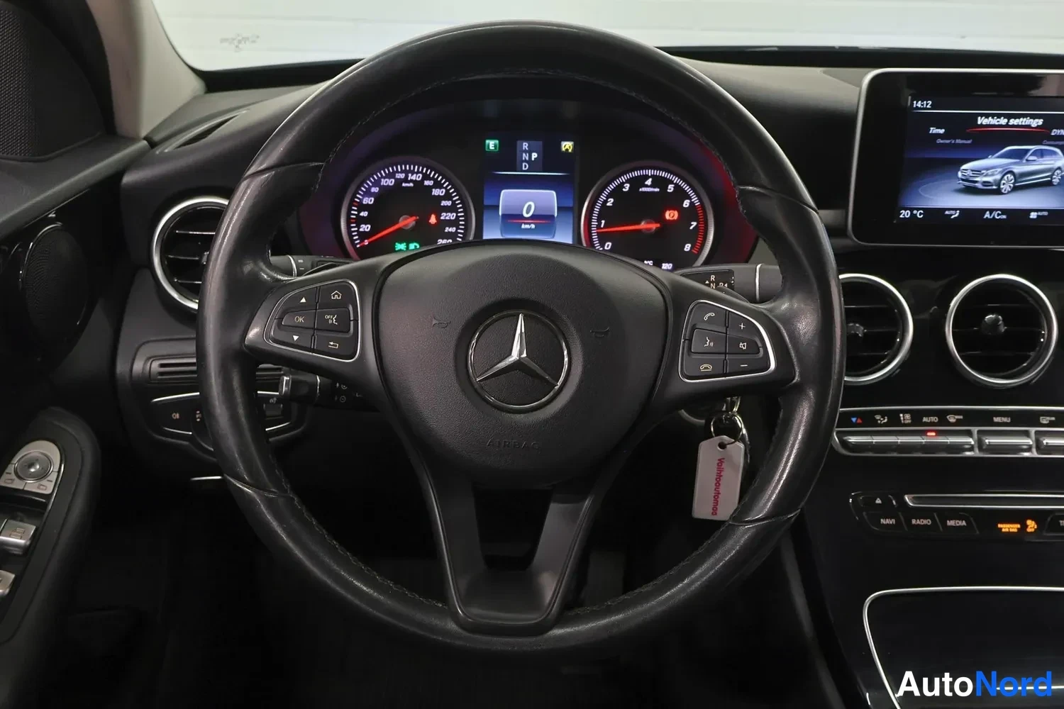 Edestä: Lähikuva Mercedes-Benzin ratista ja mittaristosta: analoginen nopeusmittari ja kierrosmittari, keskellä digitaalinen näyttö jossa vaihdetila P, D ja R sekä luke