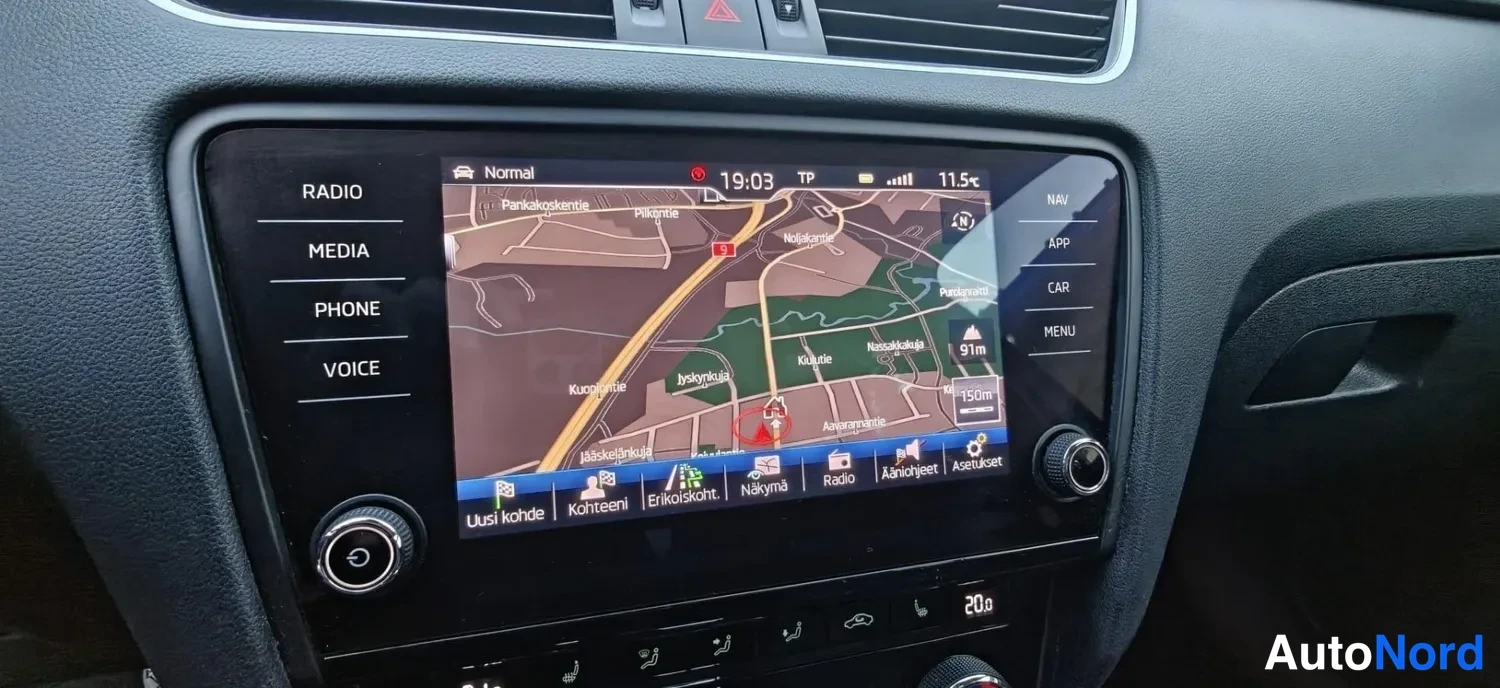 Muu: Keskikonsolin kosketusnäyttö, jolla näkyy navigointikartta; vasemmalla RADIO-, MEDIA-, PHONE- ja VOICE-painikkeet, oikealla NAV-, APP-, CAR- ja MENU-painikkeet,