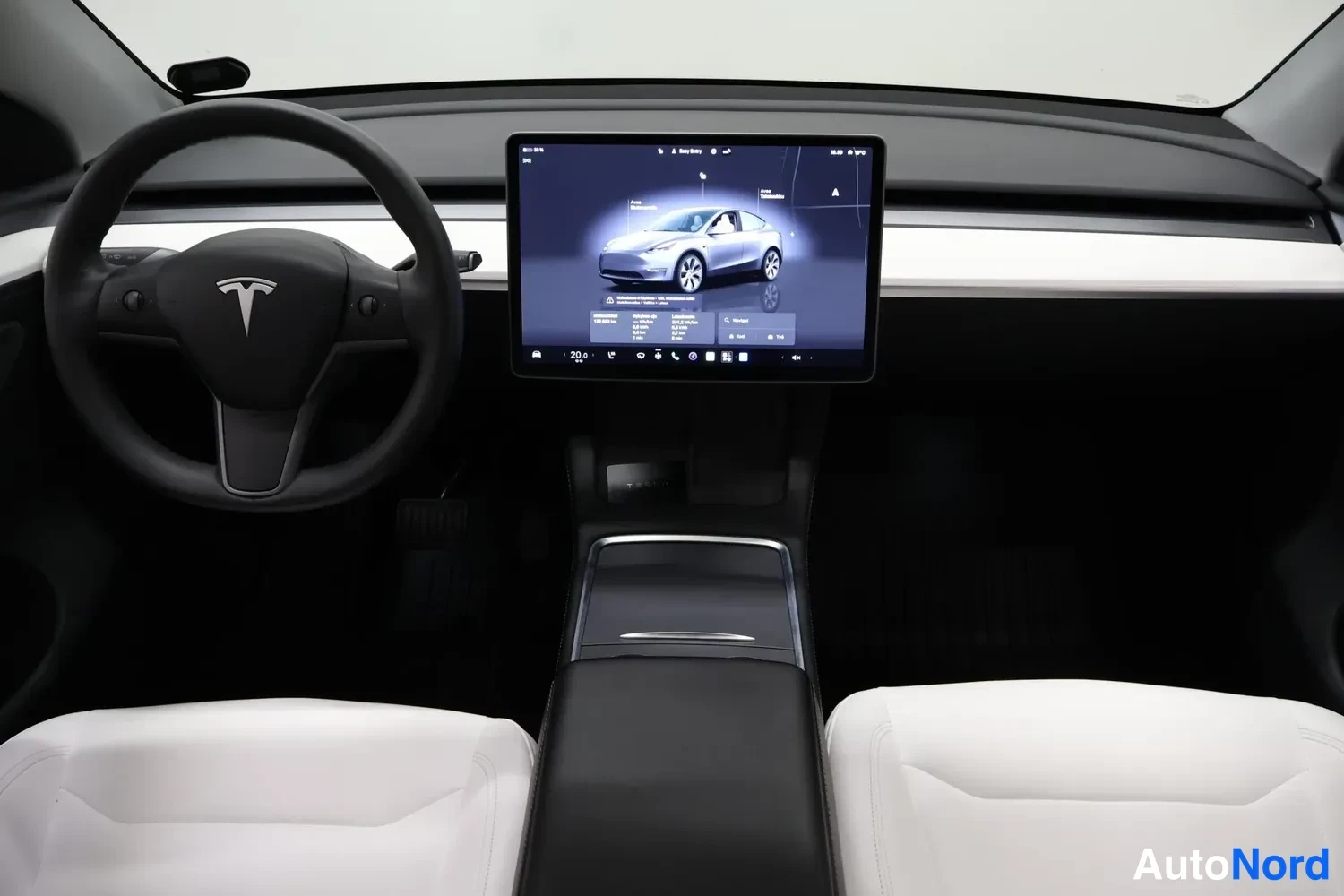 Muu: Teslaan sisäpuoli vaakakuvana: ohjauspyörä Tesla-logolla vasemmalla, keskellä suuri kosketusnäyttö, jossa auton kuva ja valikko, keskikäytävä ja etualalla kaksi