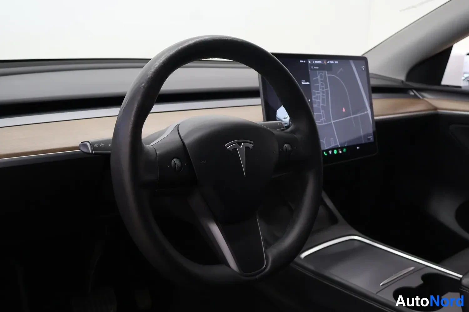 Muu: Tesla-autojen ohjauspyörä ja infotainment-näyttö, kartta näkyy näytöllä.
