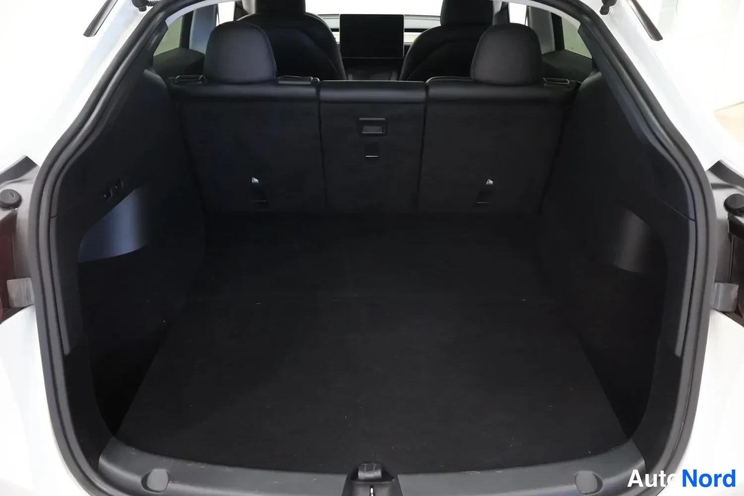 Tavaratila: The interior of an empty cargo trunk with the rear seats visible in the background.