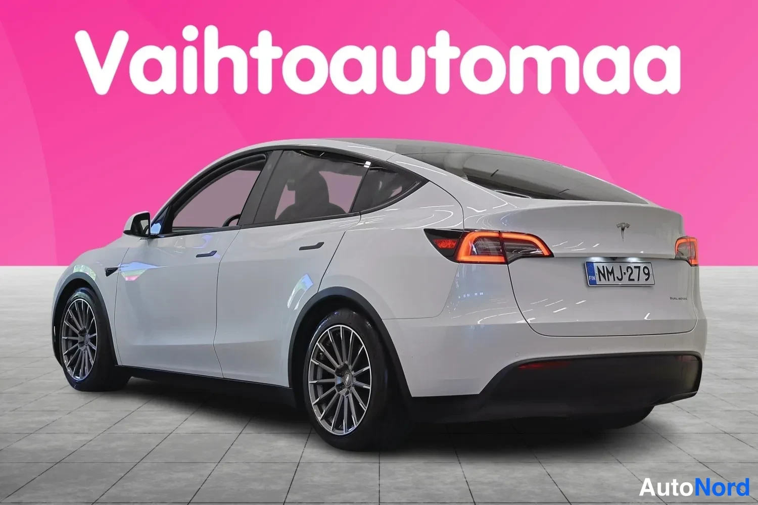 Takaviisto: Tesla Model Y -henkilöauton takaosa ja vasen kylki valkoisena kuvattuna studioakustaa vasten, rekisterikilpi.