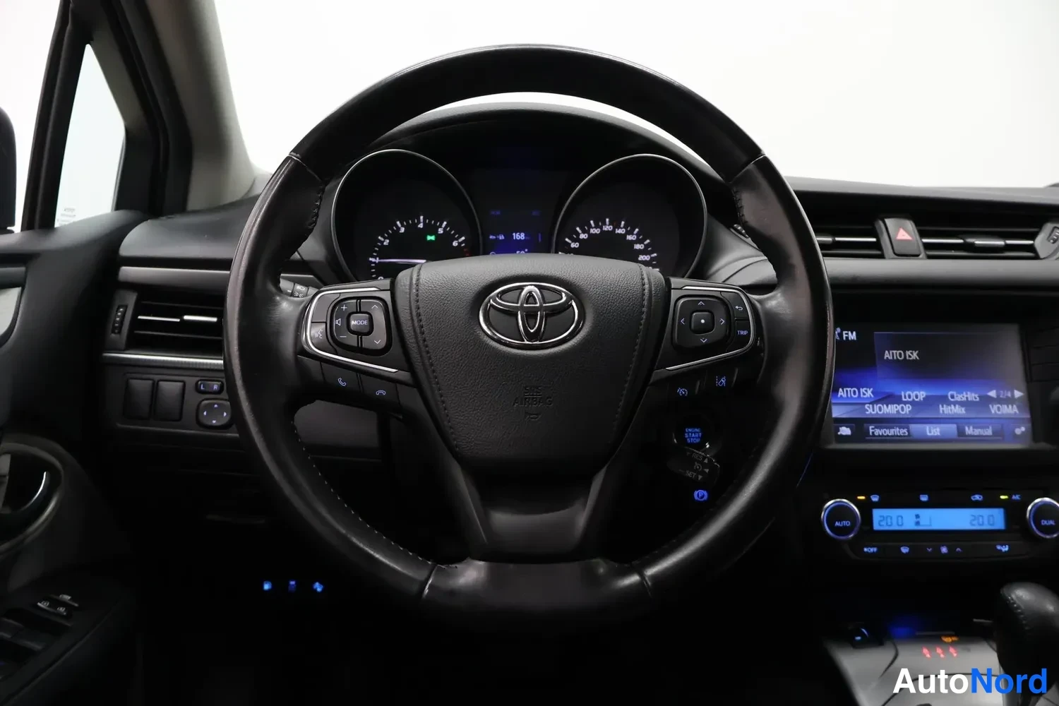 Muu: Ohjauspyörä ja mittaristo suoraan edestä: Toyota-merkki, digitaalinen näyttö ja radioasemalista AITO ISK, SUOMIPOP, VOIMA.