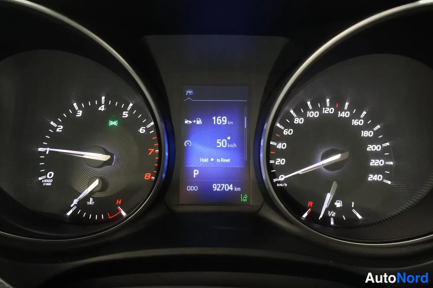 Sivulta: Kojelaudan mittaristo: nopeus- ja kierrosmittarit sekä näytön tiedot 169 km, 50 km/h, ODO 92704 km ja P-vaihde.