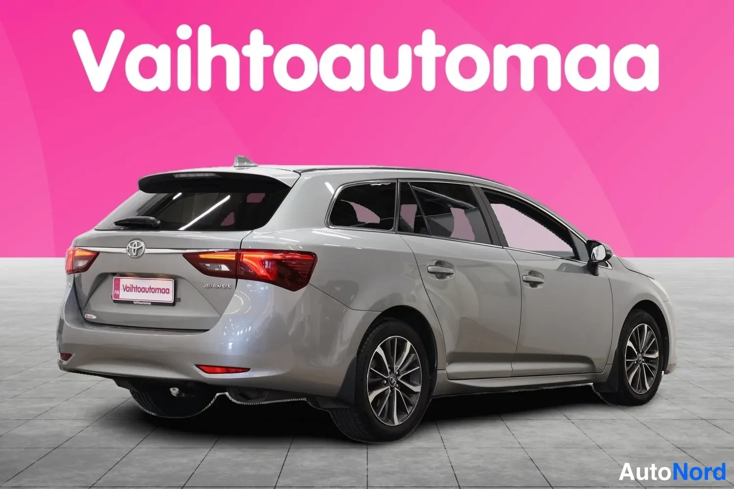 Takaviisto: Hopeanharmaa farmariauto takaa vasemmalta viistosti kuvattuna, takapää ja sivuprofiili näkyvissä, Toyota-merkki takaluukussa.