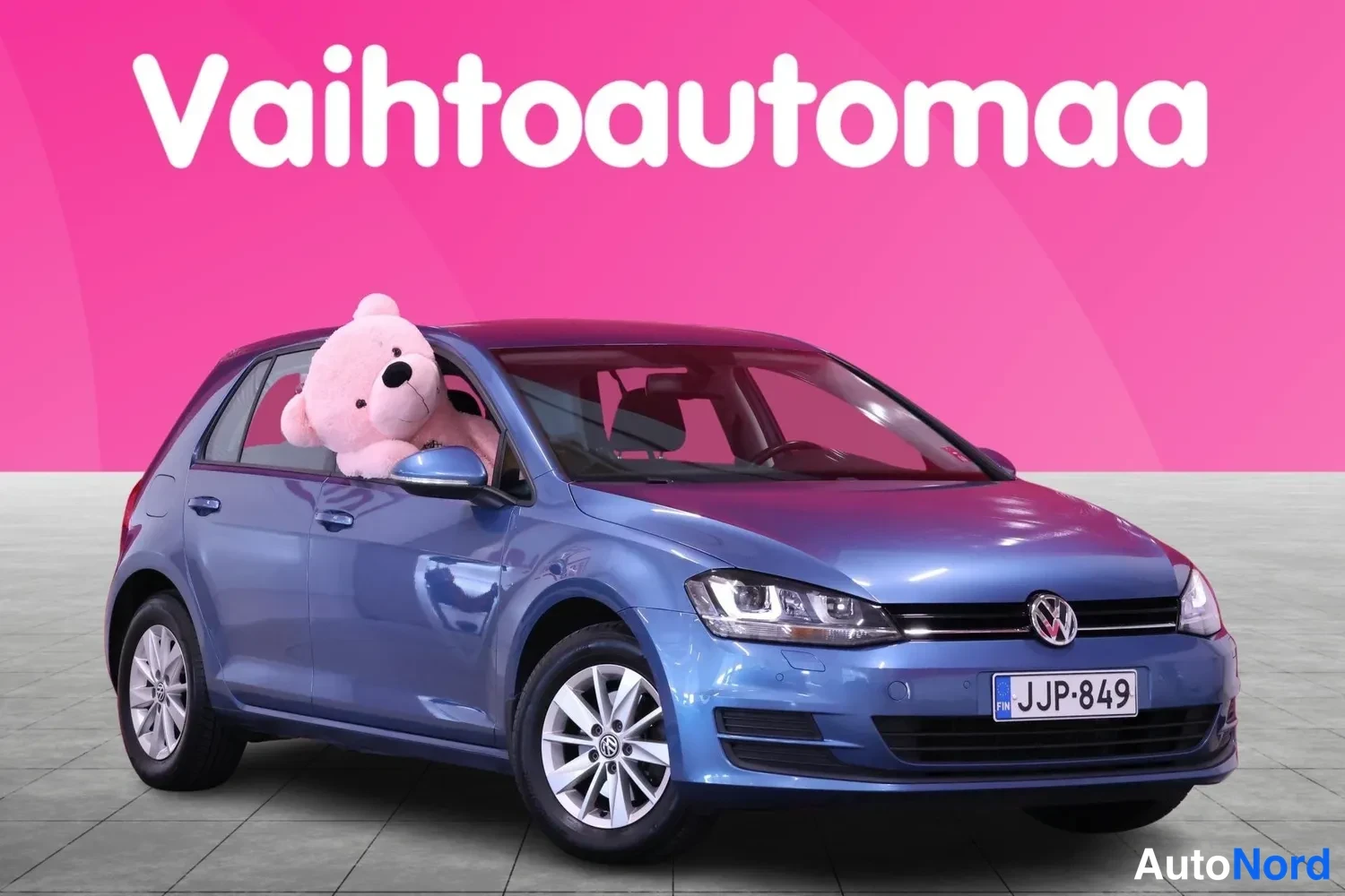 Etuviisto, nokka oikealle: Sininen Volkswagen Golf esitettynä etukulmasta oikealta, rekisteritunnus, pehmolelu ikkunassa
