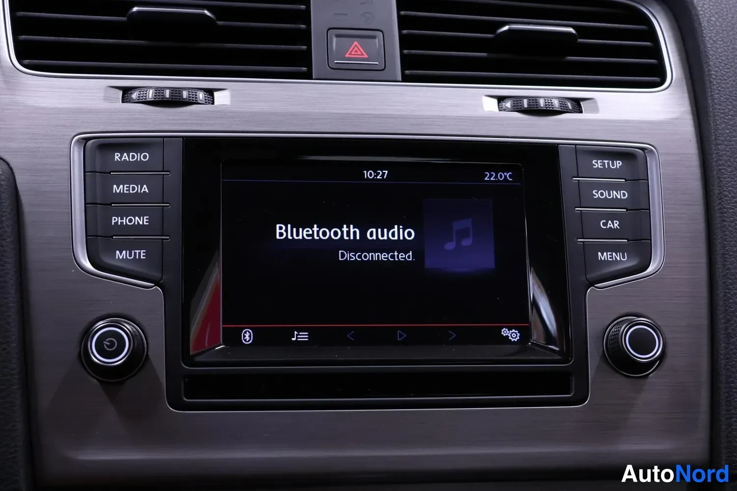 Yksityiskohta: Kojelaudan keskikonsoli: infotainment-näyttö näyttää tekstiä 'Bluetooth audio – Disconnected.', vieressä radiopainikkeet (RADIO, MEDIA, PHONE, MUTE) ja (SETUP,