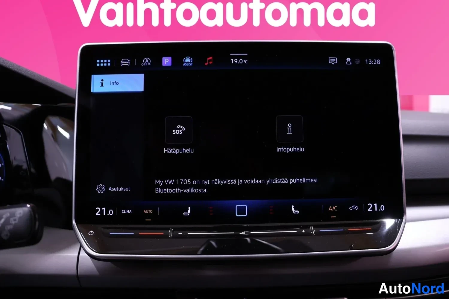 Muu: Auton kosketusnäytön Info-näkymä, jossa vaihtoehdot Hätäpuhelu ja Infopuhelu sekä teksti My VW 1705 -kytketyksestä ja ilmastointiasemat 21,0 astetta.