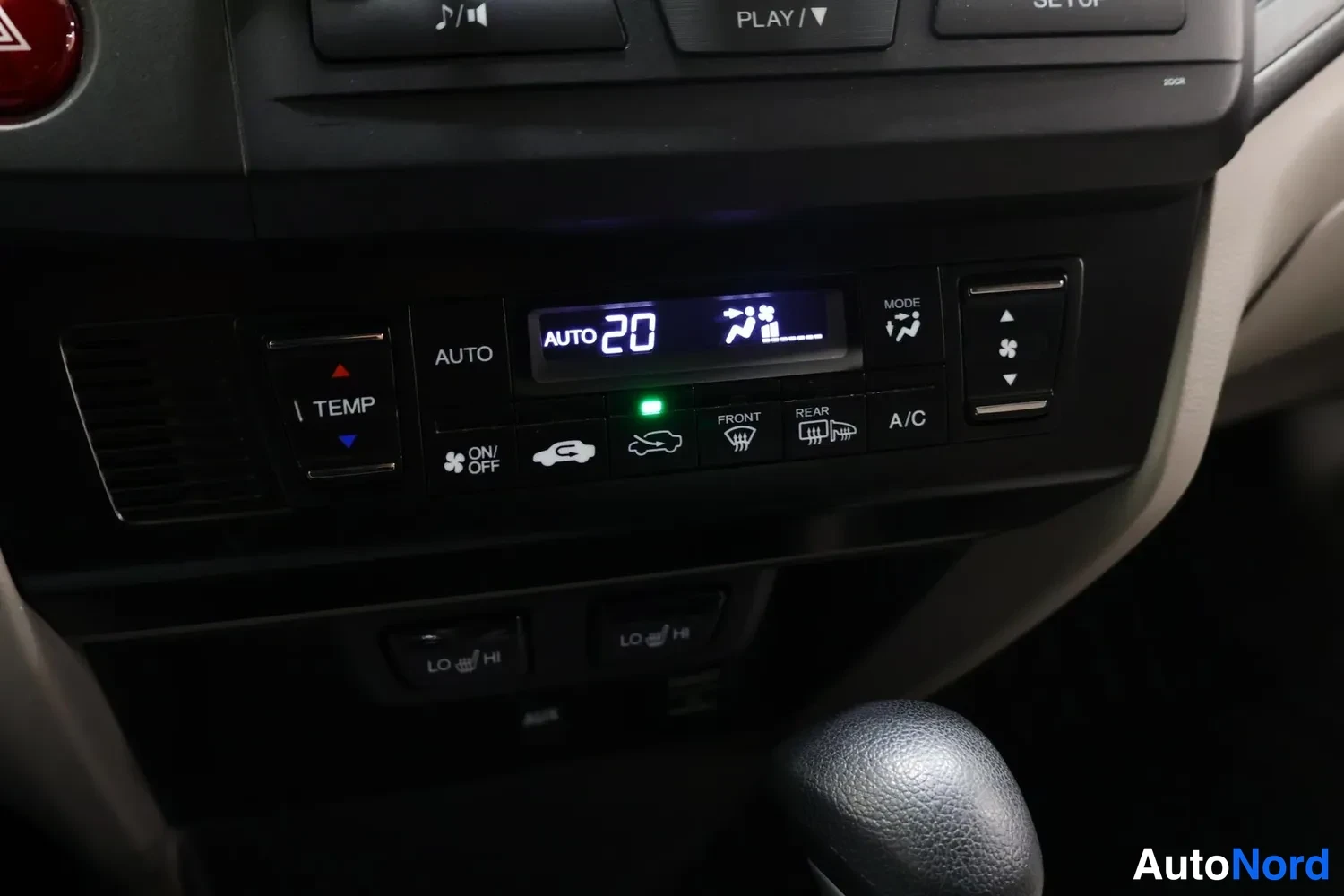 Yksityiskohta: Ilmastointilaitteen ohjauspaneeli, näytössä AUTO 20, painikkeet AUTO, A/C, FRONT ja REAR.