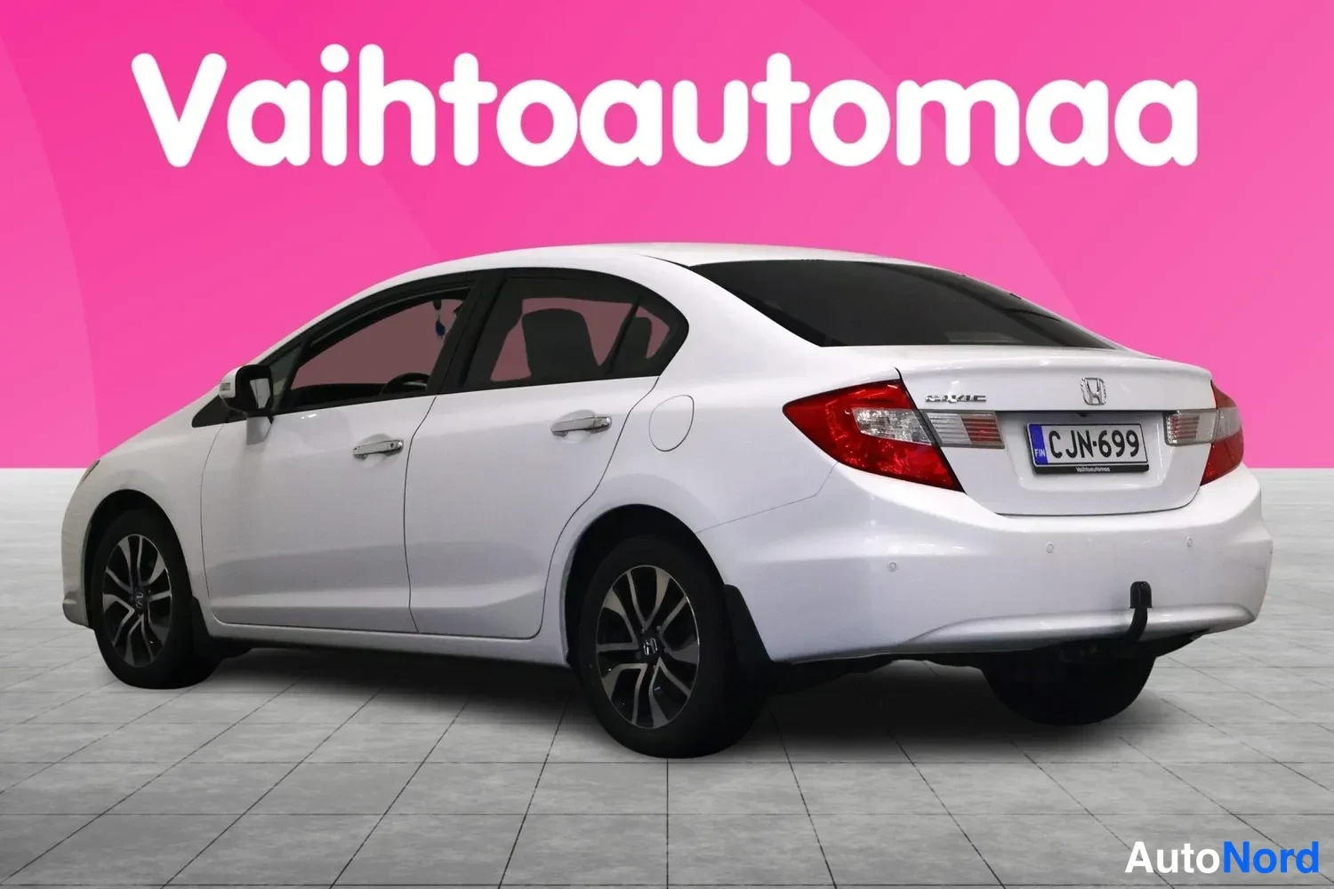 Takaviisto: Valkoinen Honda Civic -sedan takapää vasemmalle kulmasta kuvattuna, rekisteritunnus ja Civic-merkintä takaluukussa.