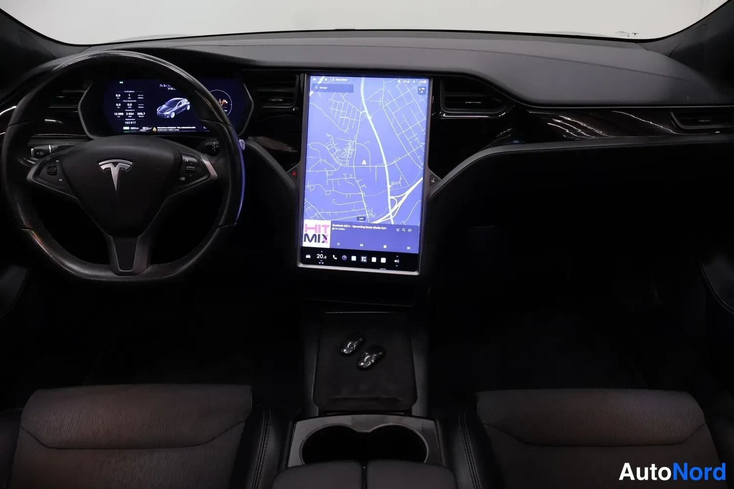 Muu: Auton sisätilat: kuljettajan puolen ohjaamo, Tesla-merkitty ohjauspyörä, digitaalinen mittaritaulu ja keskitörmän suuri karttanäyttö.