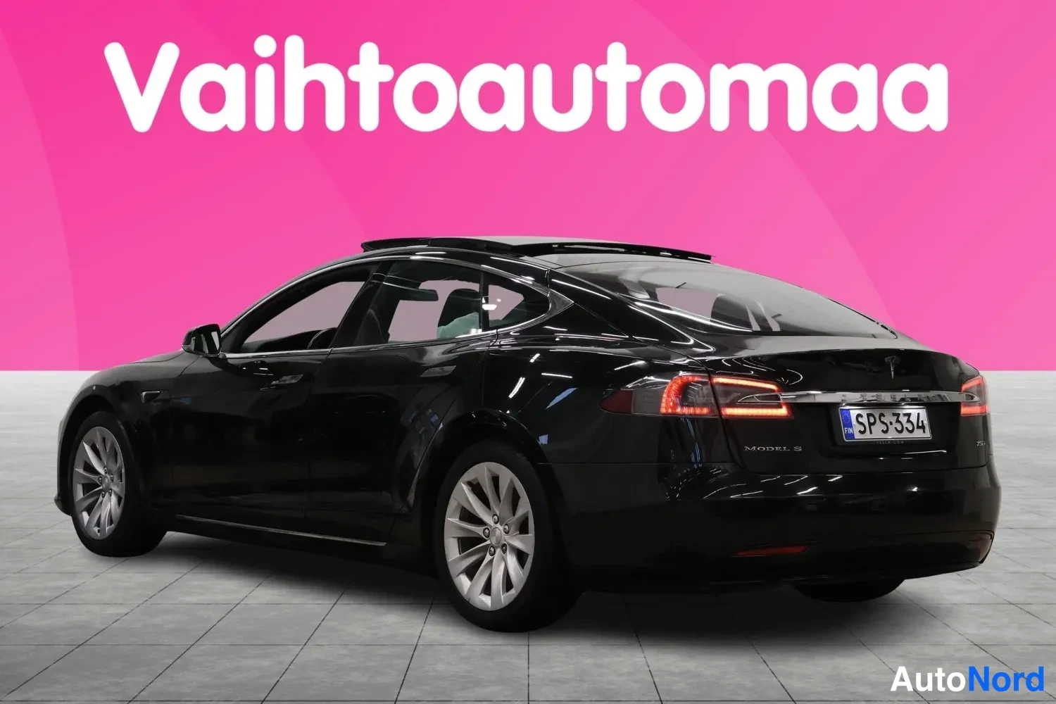 Takaviisto: Mustan Tesla Model S:n takaosan kolmasosakuva; takavalojen palot näkyvät, rekisteri, hopeavanteet.