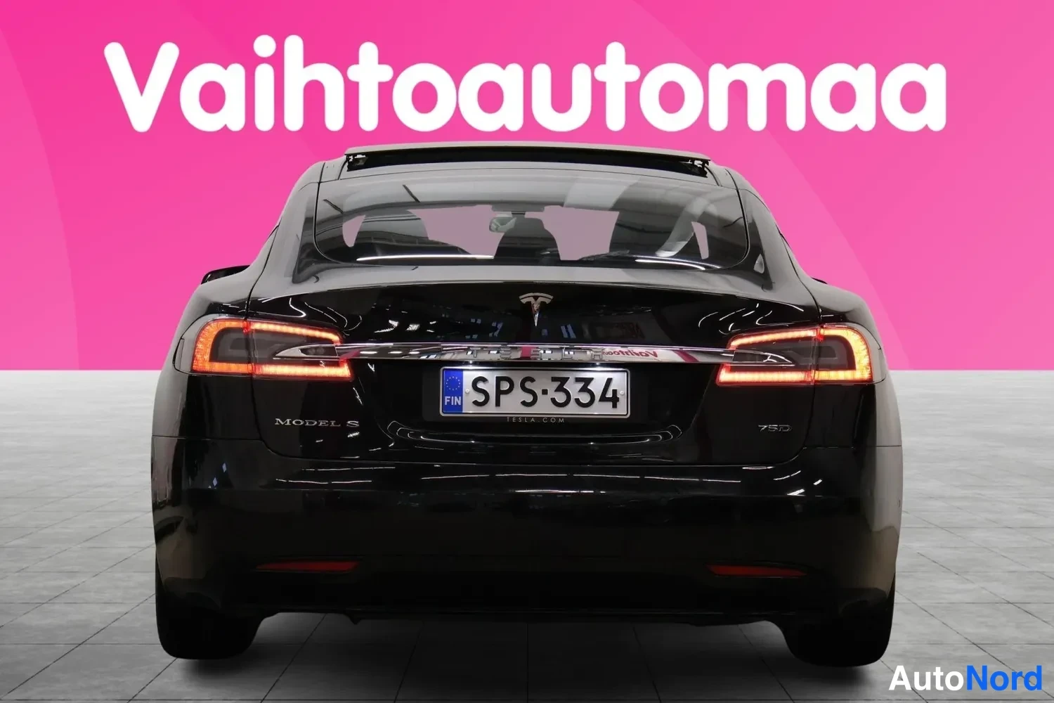 Takaa: Suora takaotakkuva mustaan Tesla Model S:iin; takavalojen palot, rekisteri ja mallimerkinnät Model S ja 75D.