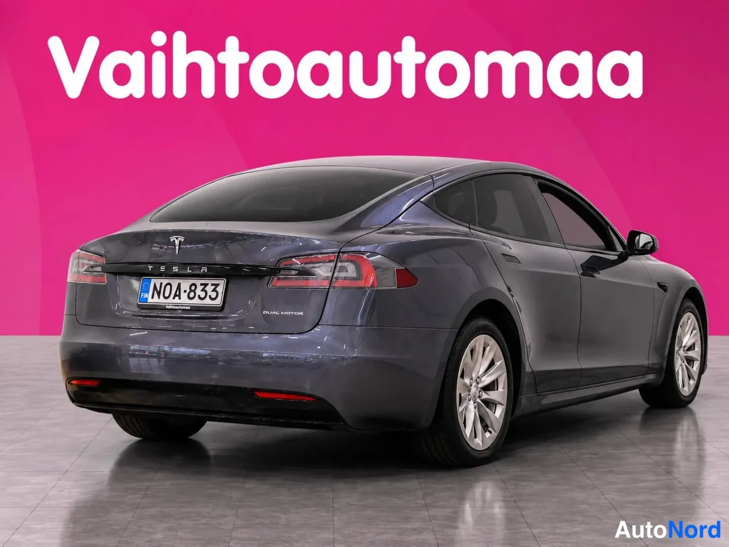 Takaviisto: Tummansininen Tesla Model S -sedan takaokolikuva oikealta, takaluukussa teksti 'DUAL MOTOR', rekisteritunnus.