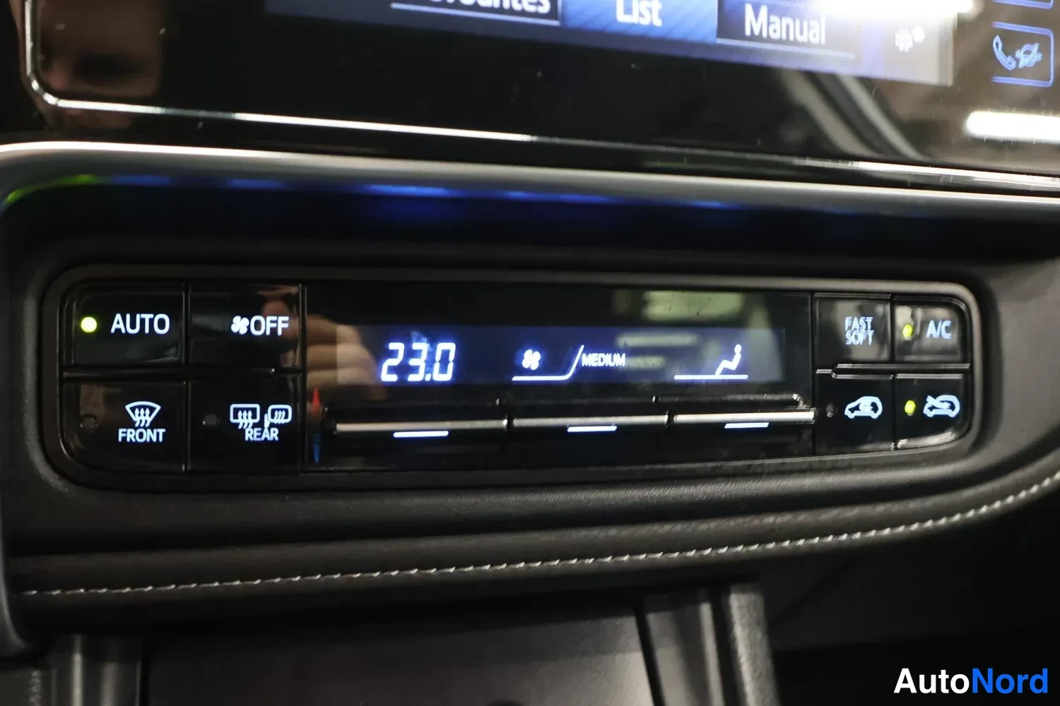 Yksityiskohta: Ilmastointilaitteen ohjauspaneeli: AUTO- ja OFF-painikkeet, tuulilasin (FRONT) ja takalasin (REAR) sulatuspainikkeet, A/C-painike sekä näyttö, jossa lukee 23.0