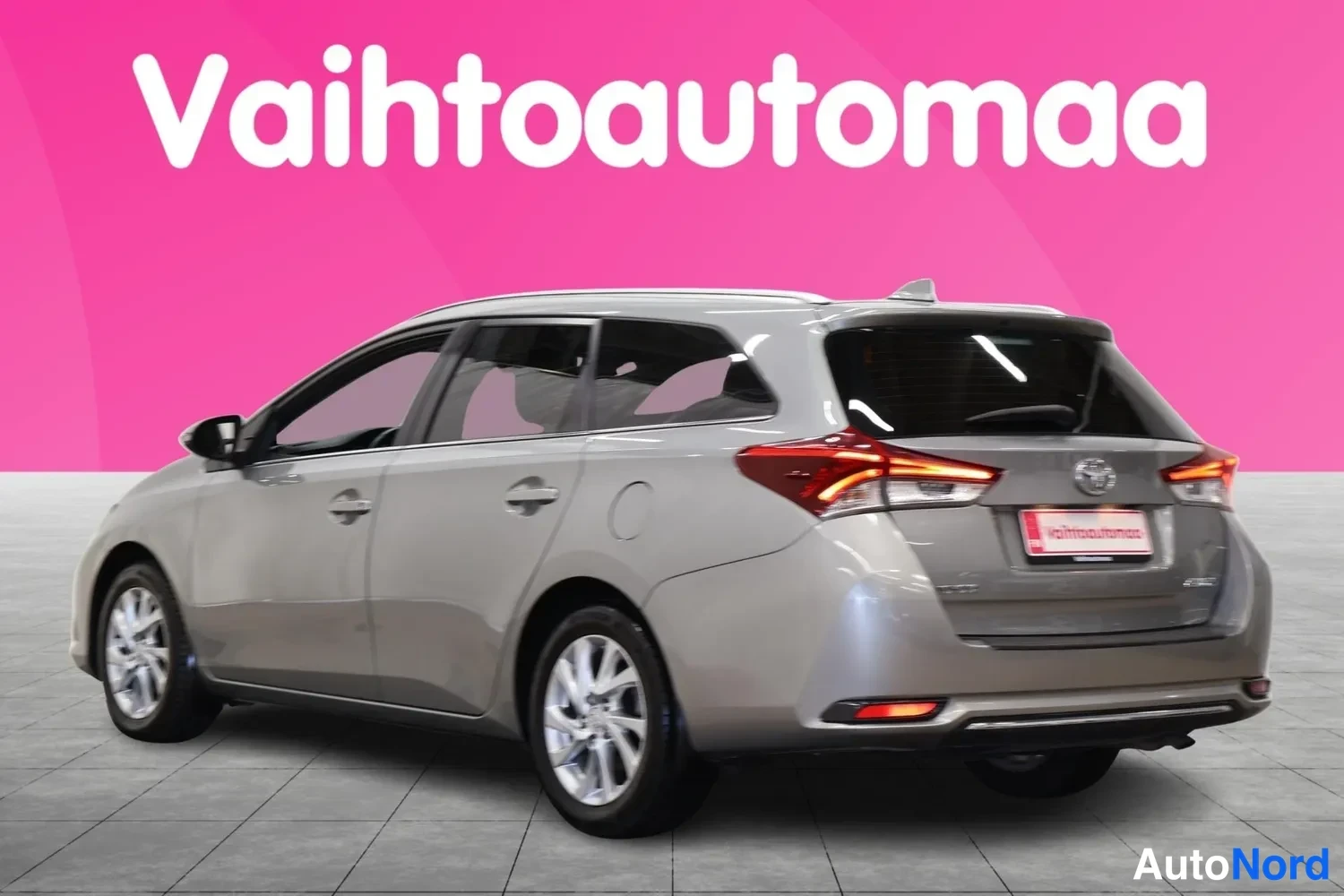 Takaviisto: Toyota Auris Touring Sports -farmariauto takaviistosta vasemmalta, vaaleanharmaa kori, takavalot ja ovenkahvat näkyvät.