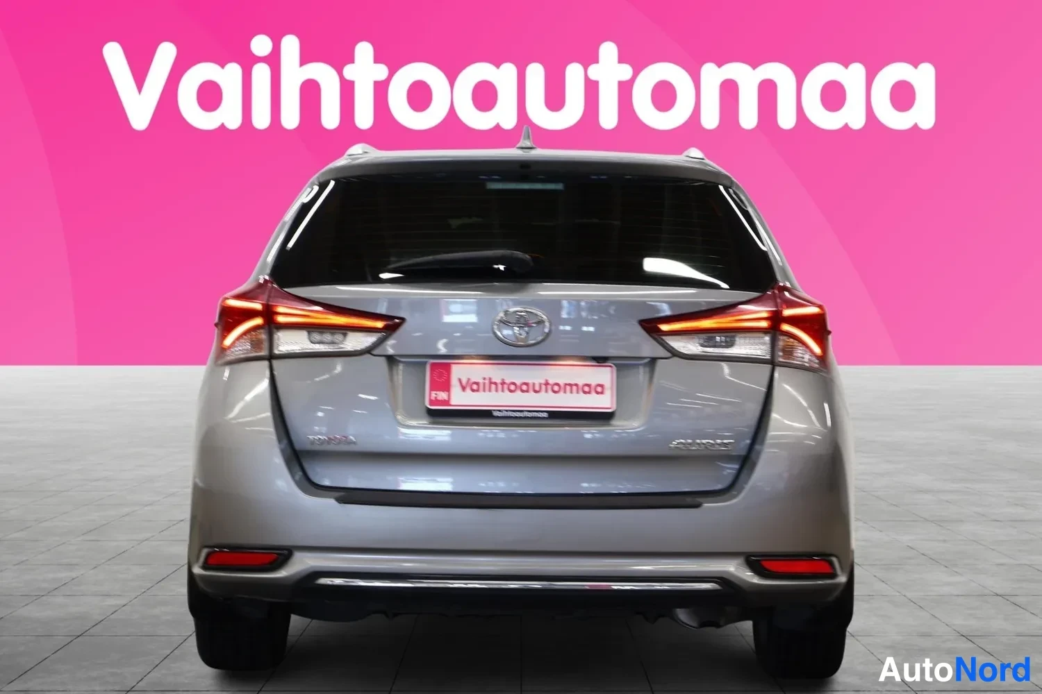Takaa: Toyota Auris Touring Sports suoraan takaa kuvattuna, takavalot, Toyota-merkki ja Vaihtoautomaa-rekisterikilpi näkyvät.