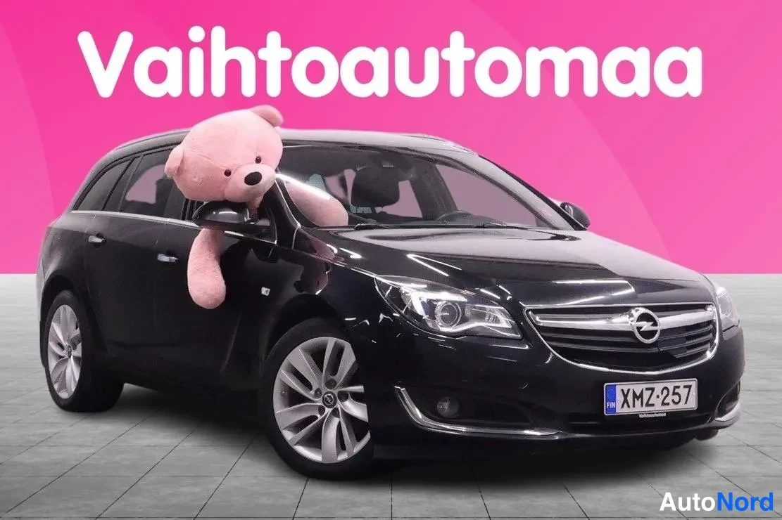Etuviisto, nokka oikealle: Mustan farmariauton keula vasemmalle kääntyneenä, rekisterikilpi, pinkki tausta.