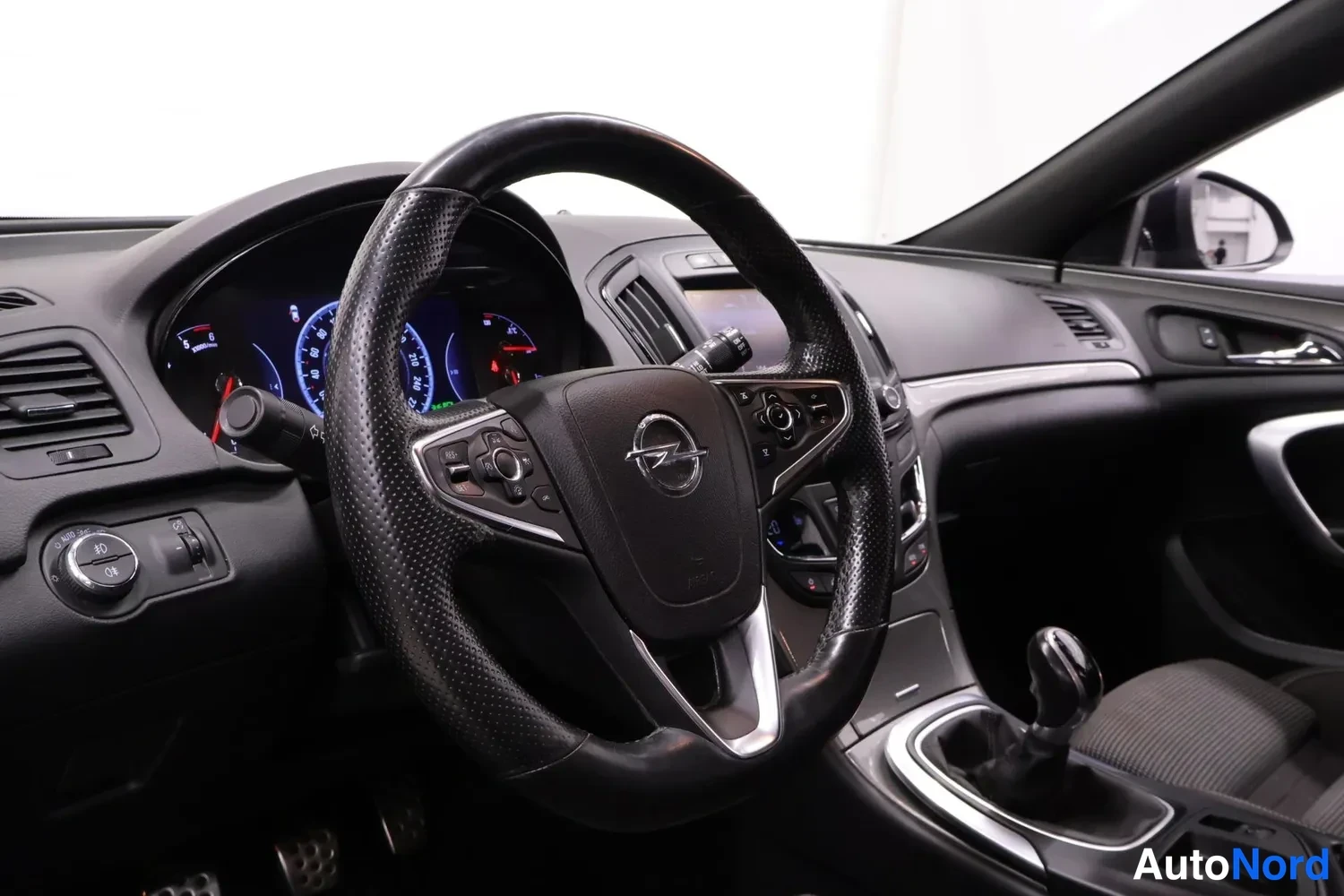 Edestä: Opel-merkkinen ratto, mittaristo ja manuaalivaihteisto.