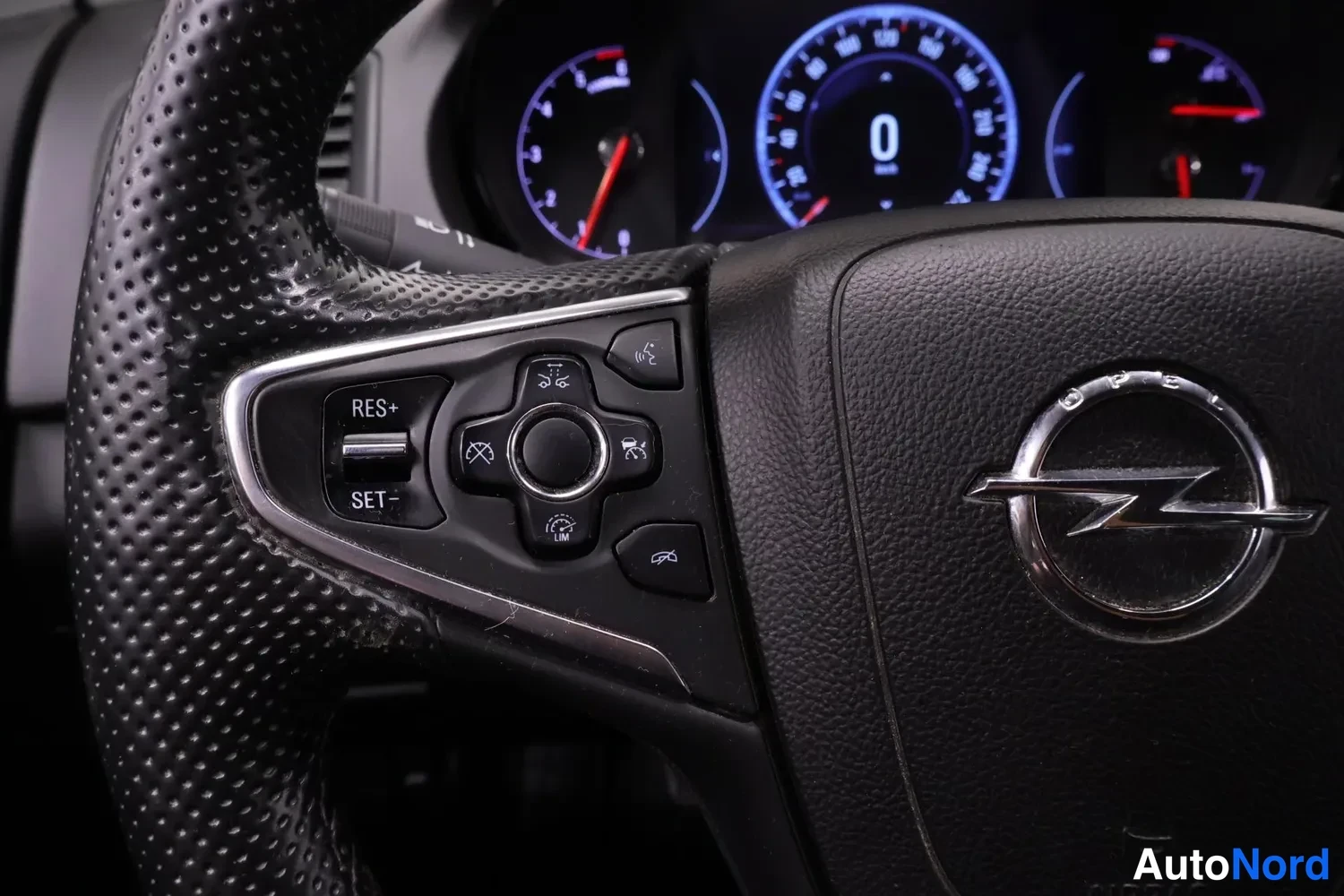 Muu: Lähikuva Opel-merkityn ohjauspyörän puhalluspinta- ja ratti painikkeista: RES+, SET-, LIM ja kyykityskontrollit.