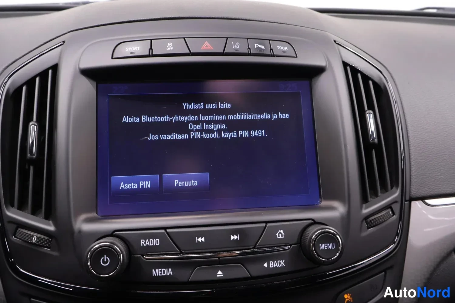 Muu: Infotainment-näytön Bluetooth-kytkentäruutu suomeksi, PIN-koodi 9491 ja valinnat 'Aseta PIN' ja 'Peruuta'.