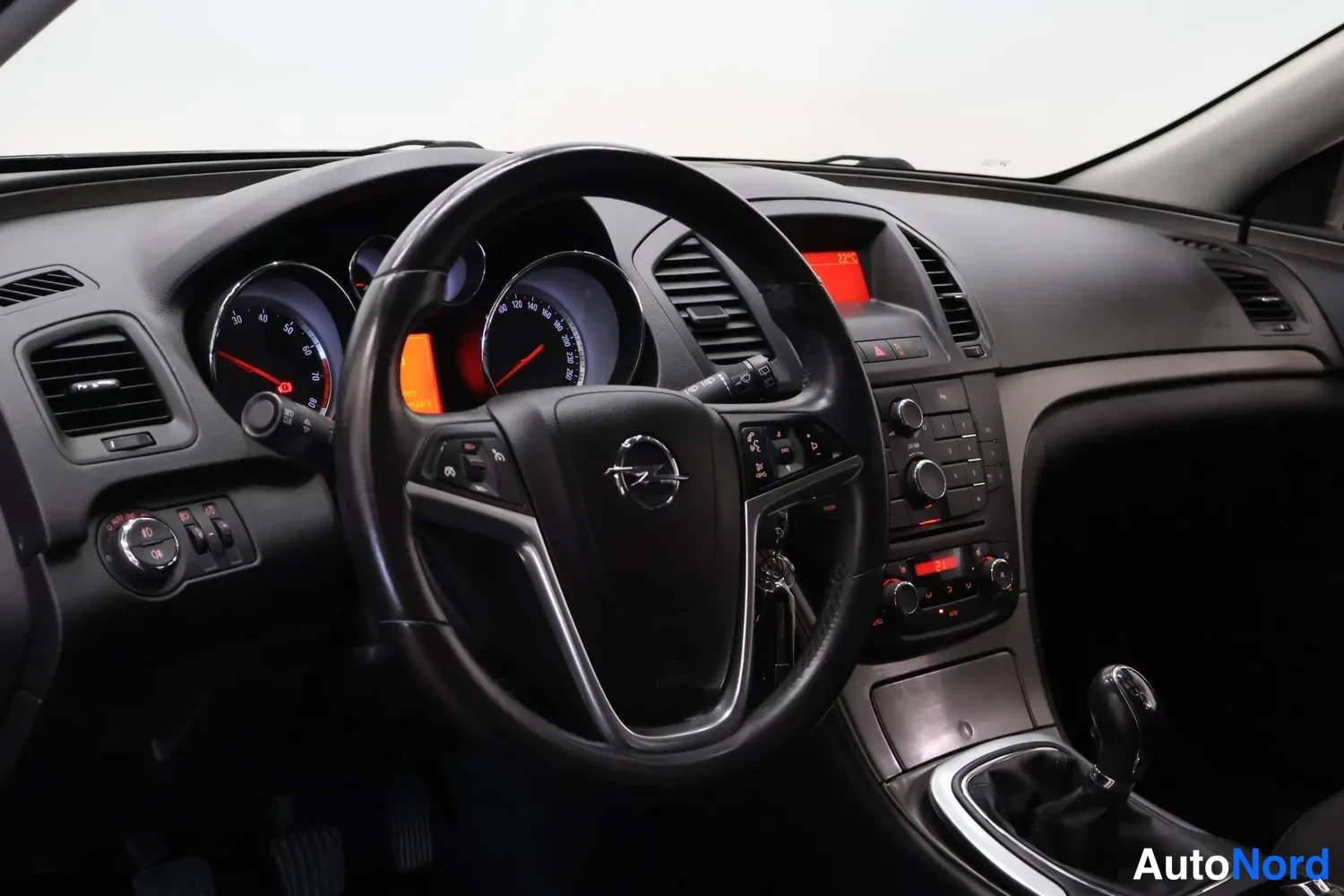 Muu: Opel-merkkiohjauspyörä ja kojelauta, mittaristo punaisilla valokeiloilla, manuaalivaihtoehdon keksi ja radio-näppäimistö näkyvissä.