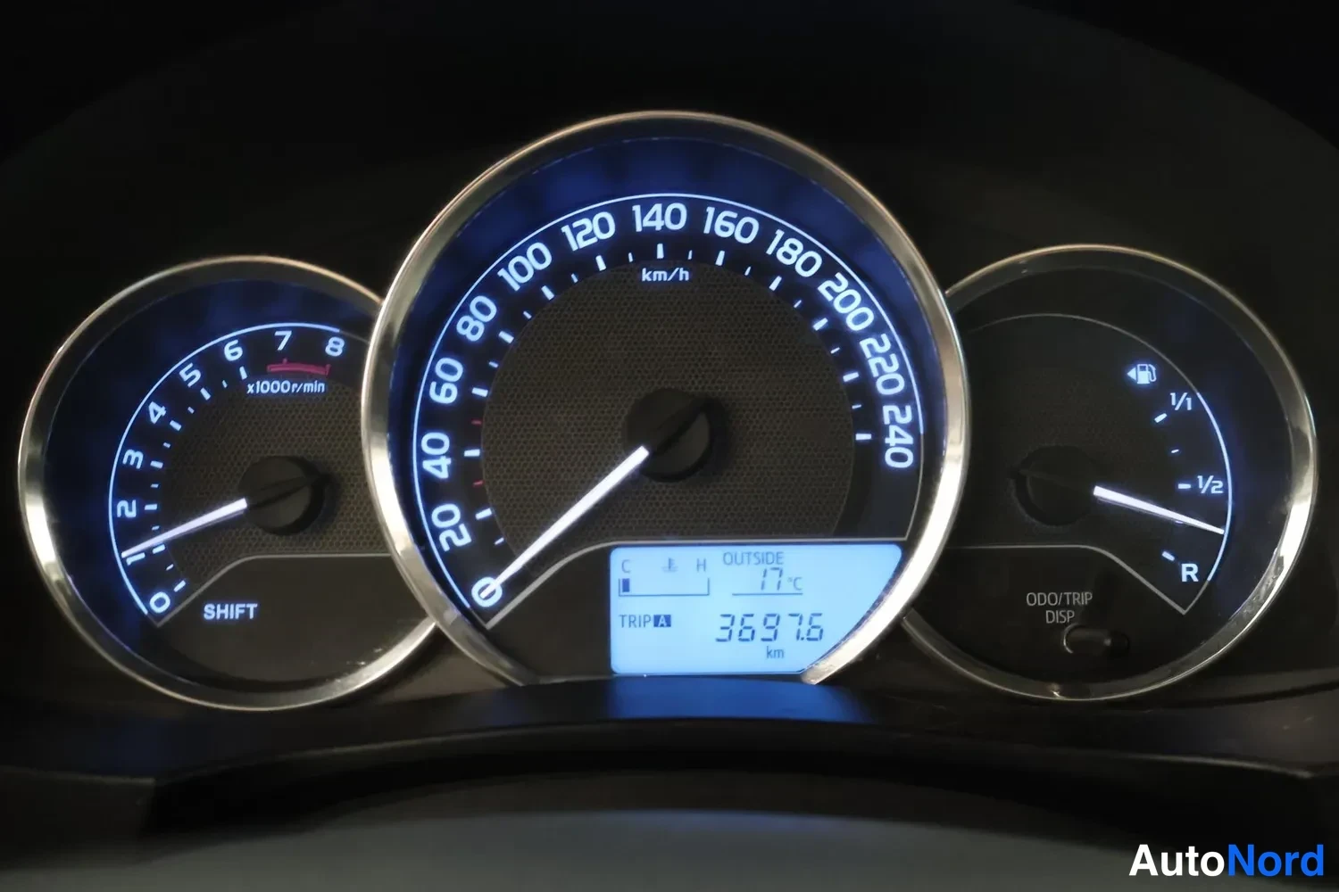 Yksityiskohta: Mittaristo: nopeusmittari asteikolla 0–240 km/h, kierrosmittari 0–8 x1000r/min ja polttoainemittari; näytössä TRIP A 3697.6 km ja ulkolämpötila 17 °C.