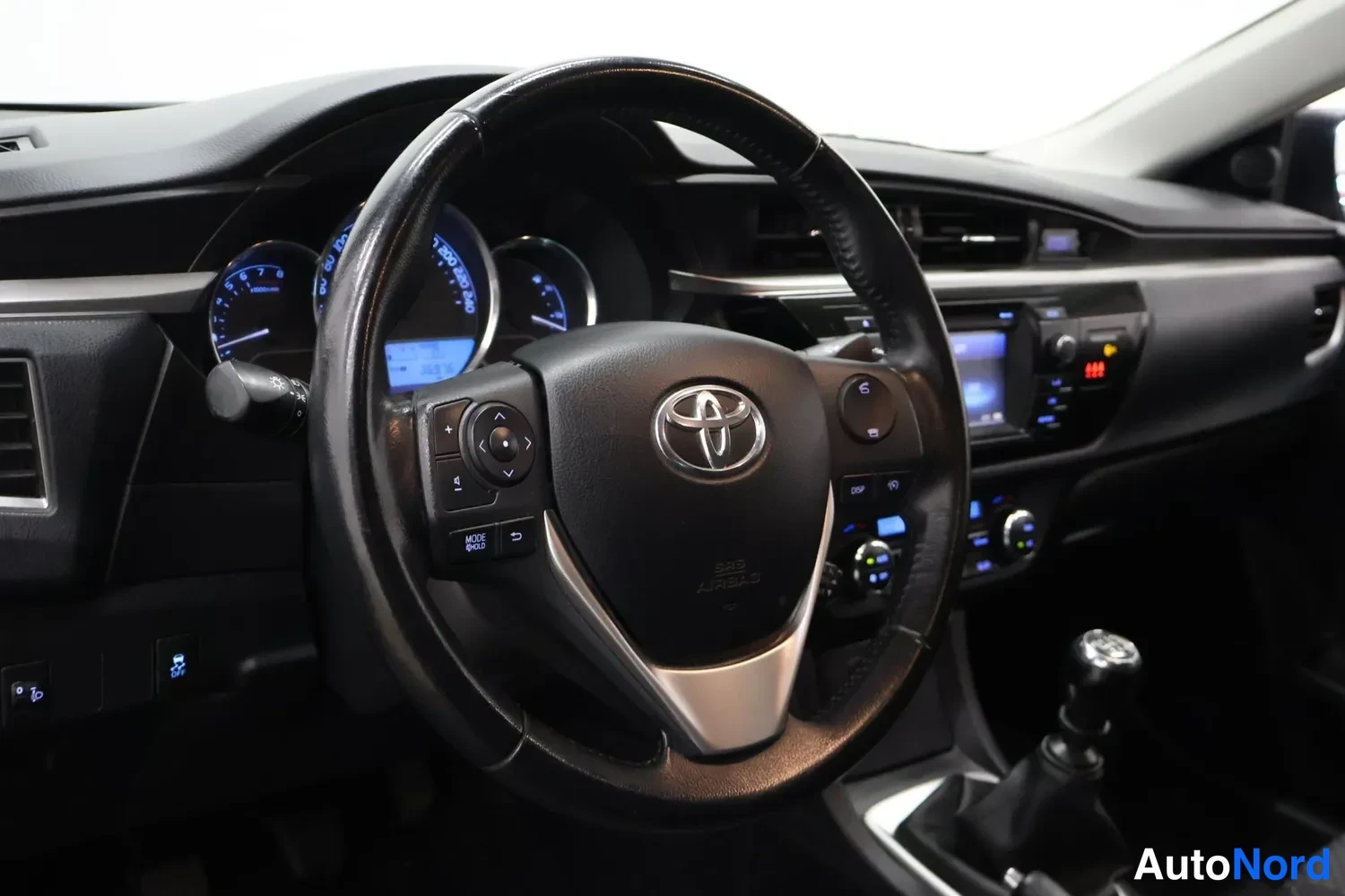 Muu: Ohjauspyörä, mittaristo ja manuaalivaihteiston vaihdekeILA Toyota Corollan sisätiloissa.