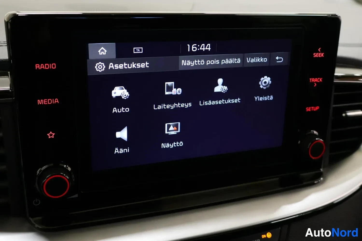 Yksityiskohta: Auton radio/näyttöyksikkö näyttää asetusvalikkoa vaihtoehdoilla Auto, Laiteyhteys, Lisäasetukset, Yleistä, Ääni ja Näyttö.