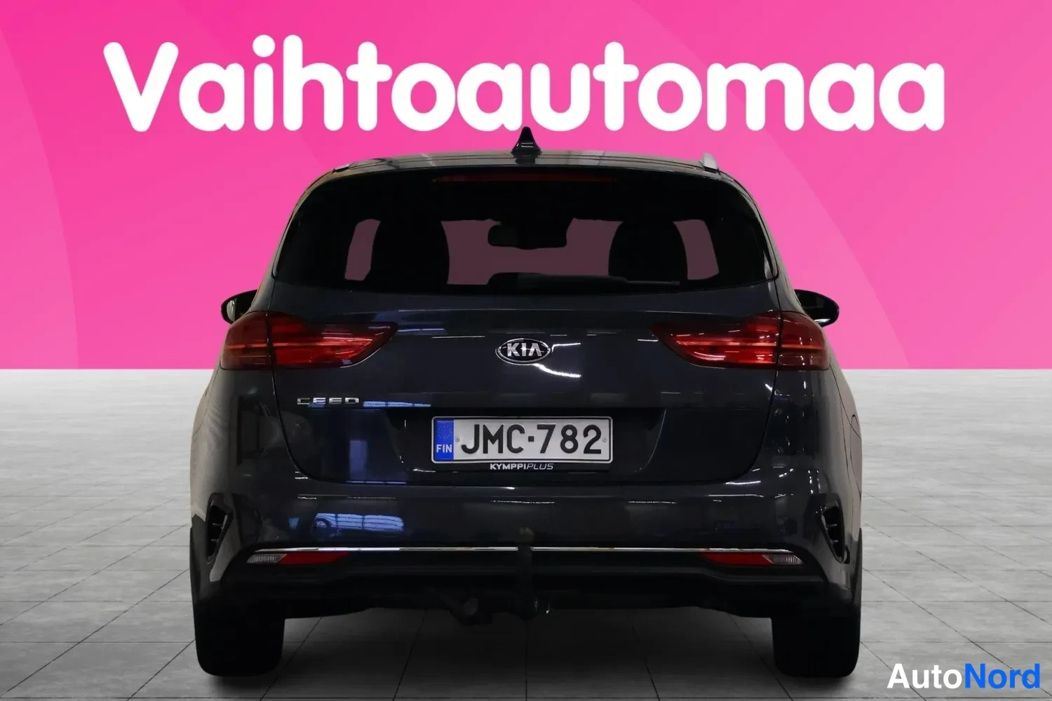 Takaa: Tummansinisen Kia Ceed Sportswagonin takaosa suoraan takaa, KIA- ja Ceed-merkinnät sekä rekisteri näkyvät.