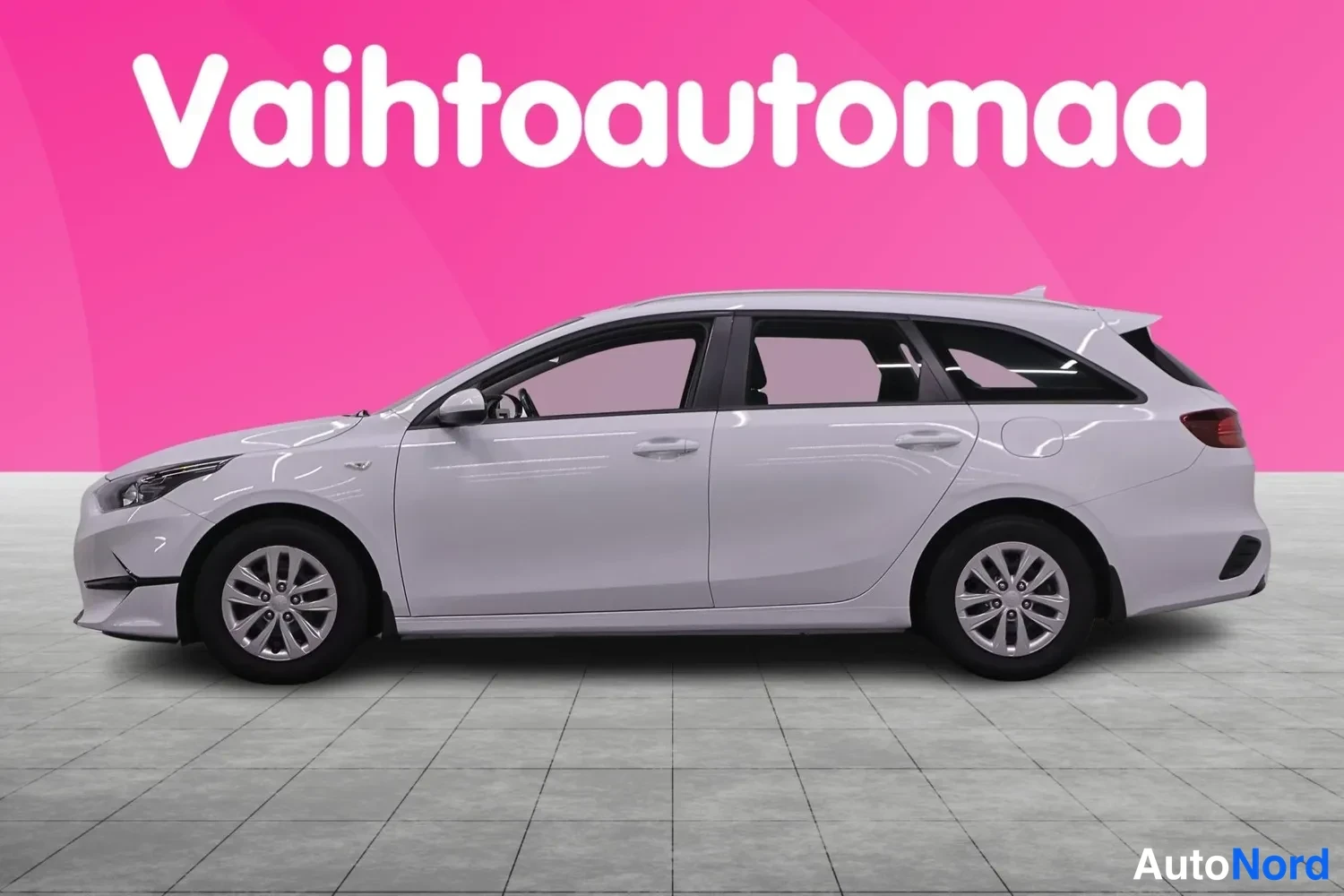 Sivulta: Kia Ceed -asema-auto valkoiselta sivulta, molemmat sivupeilit ja kattoteline näkyvät.