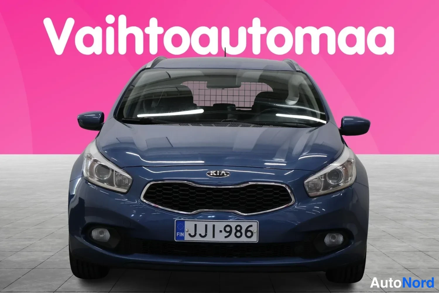 Edestä: Sininen farmariauto suoraan edestä, rekisterikilpi