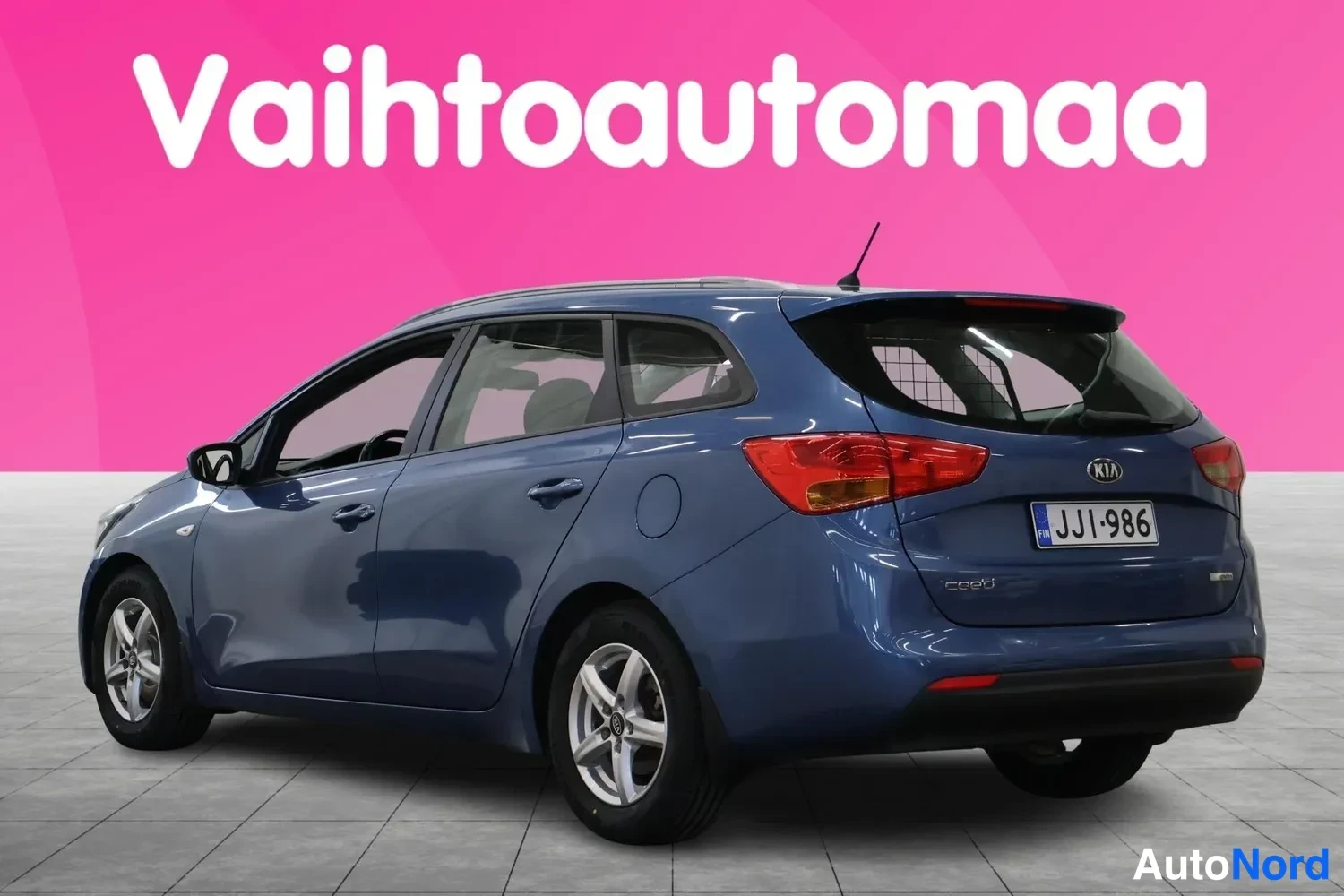 Takaviisto: Sininen Kia Ceed -farmariauto takaviistöstä kuvattuna, rekisterikilpi näkyvissä.