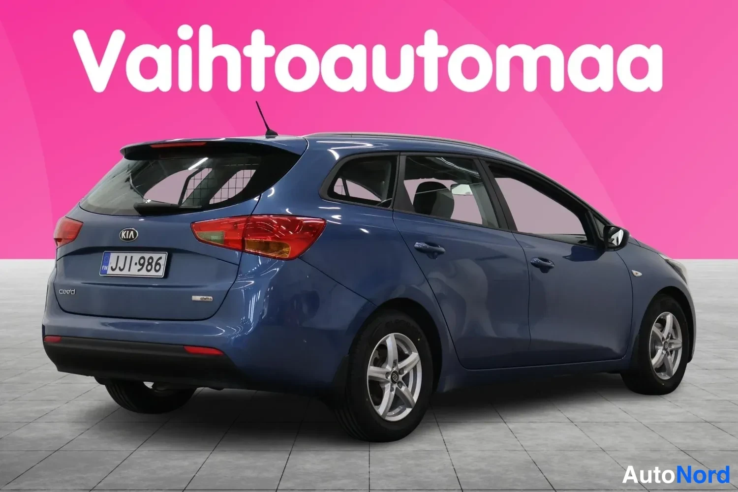 Takaviisto: Sininen Kia Ceed -farmariauto takaviistöstä oikealta kuvattuna, rekisterikilpi näkyvissä.