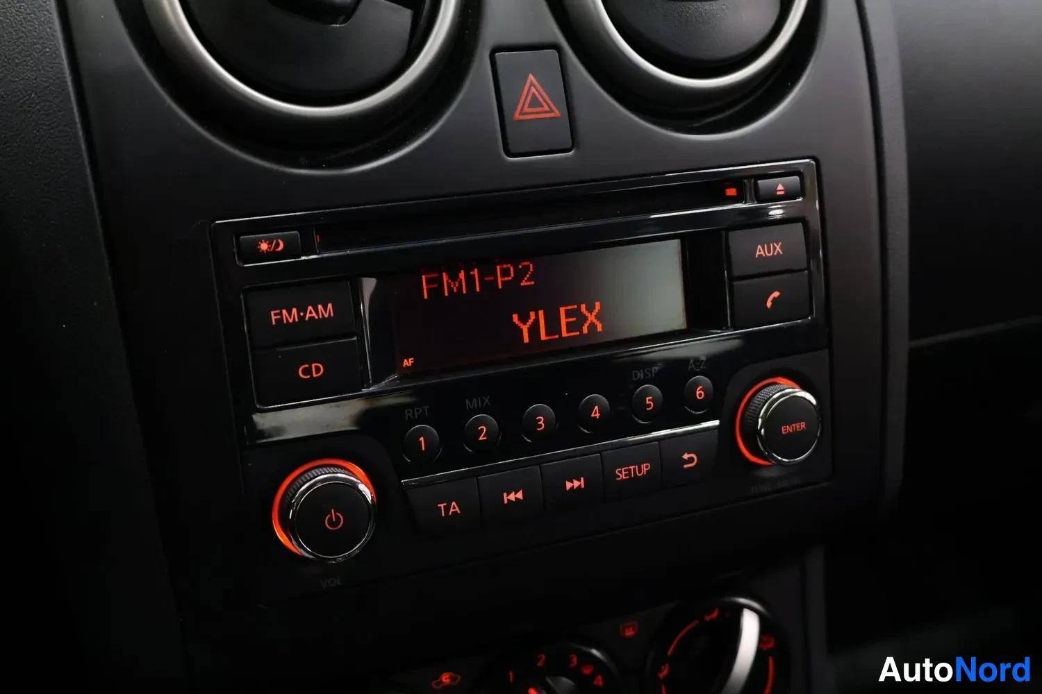 Muu: Autoradion lähikuva: näytöllä FM1-P2 ja YLEX, lisäksi CD- ja AUX-toiminnot.