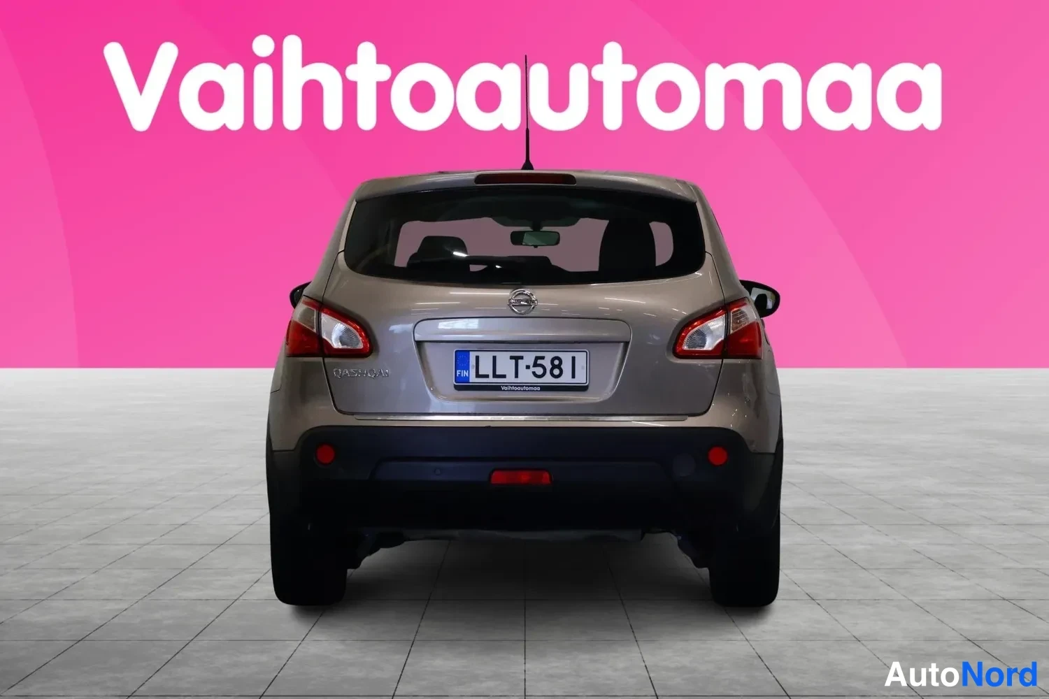 Takaa: Beige Nissan Qashqai -maastauto suoraan takaa kuvattuna, QASHQAI-teksti ja rekisterikilpi näkyvissä.