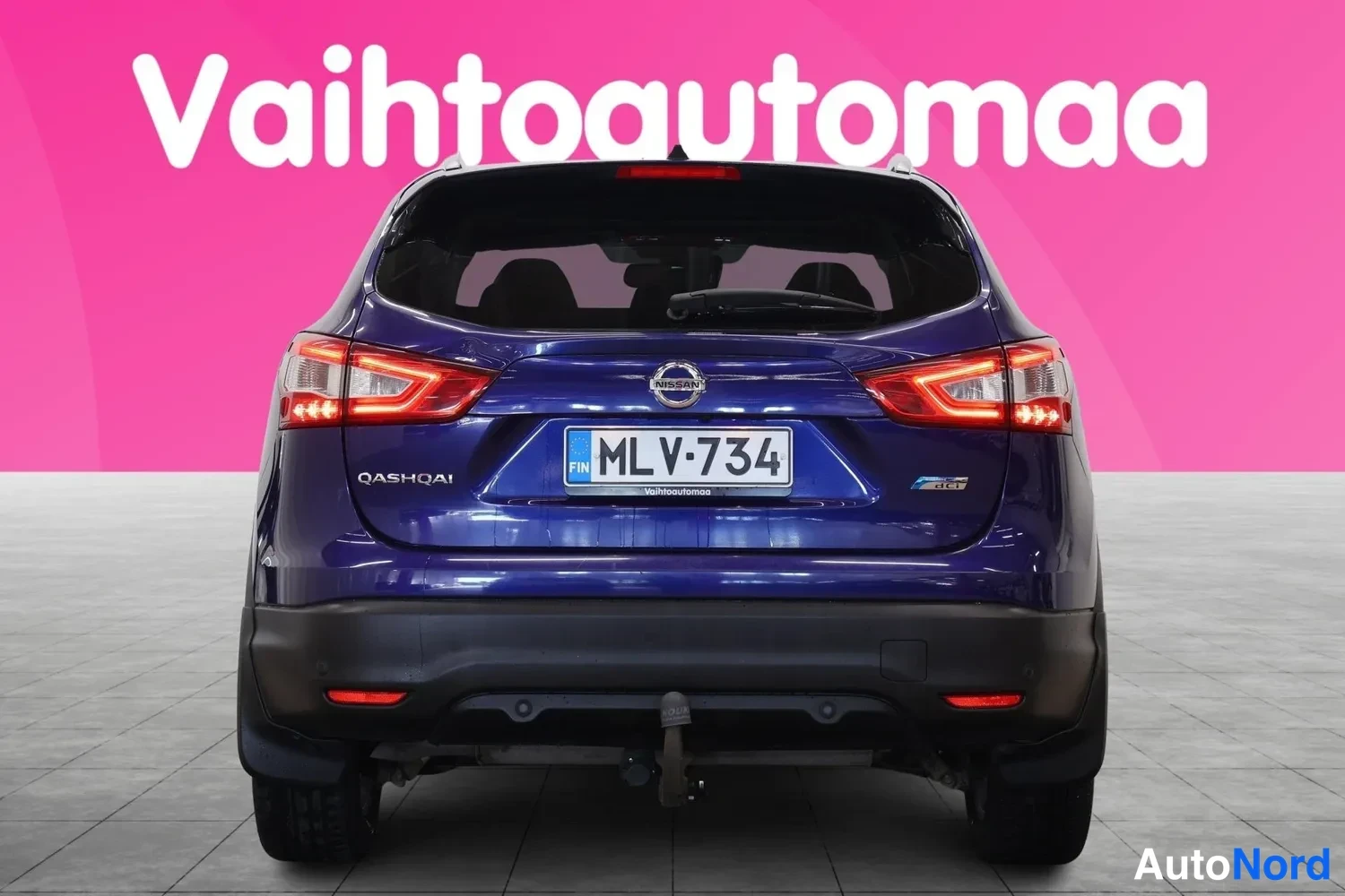 Takaa: Sinisen Nissan Qashqain takanäkymä, rekisterikilpi ja takavaloja.