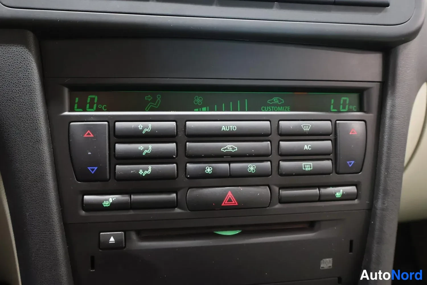 Muu: Keskinäytön alapuolella ilmastointipaneeli: AUTO ja AC-napit, lämpötilat 1,0 °C molemmin puolin, istuimien lämmitys- ja KUNNAT-symbolit, kolmionapit.
