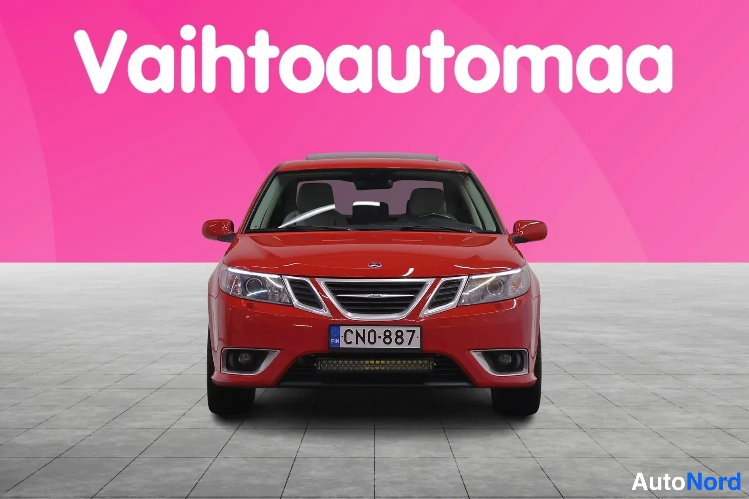 Edestä: Saab 9-3:n etunäkymä suoraan edestä, punainen kori ja rekisteritunnus.