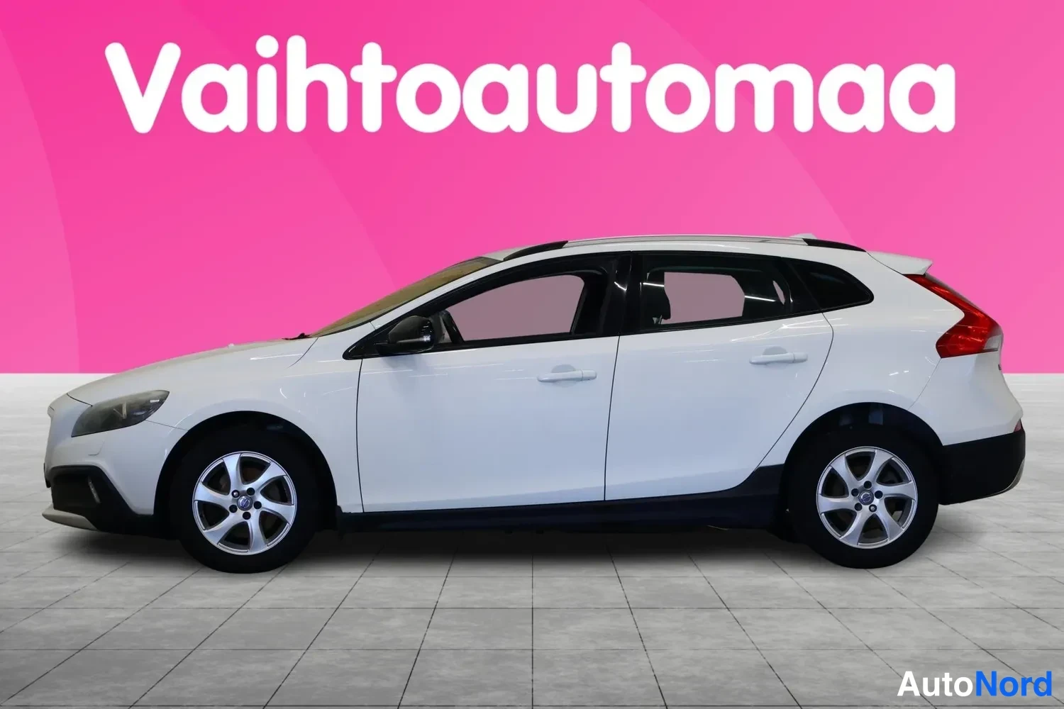 Sivulta: Valkoinen farmarimallinen henkilöauto sivulta kuvattuna.