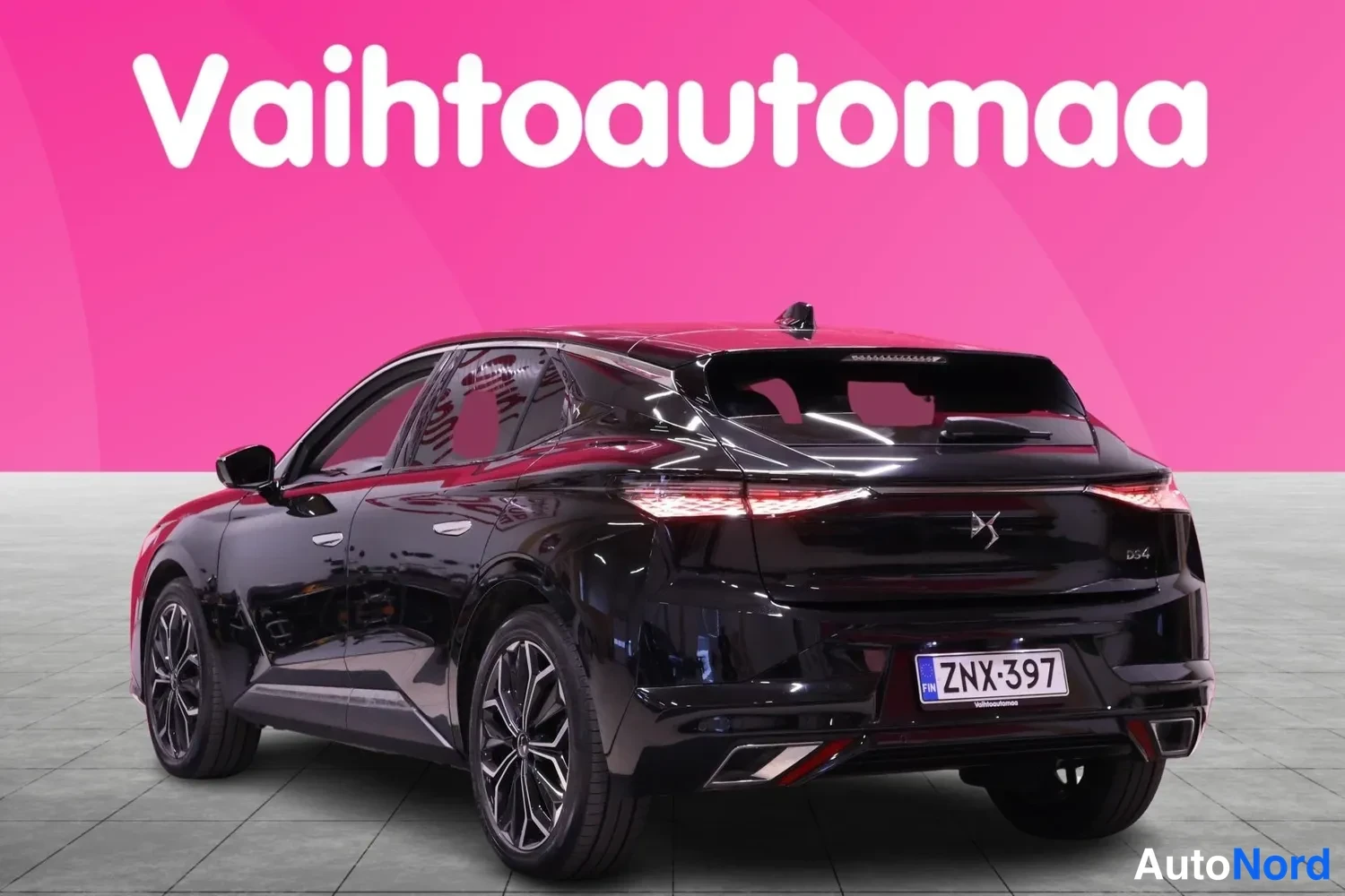 Takaviisto: Mustan auton takakulman profiili kolmesta neljäsosasta, rekisterikilpi.