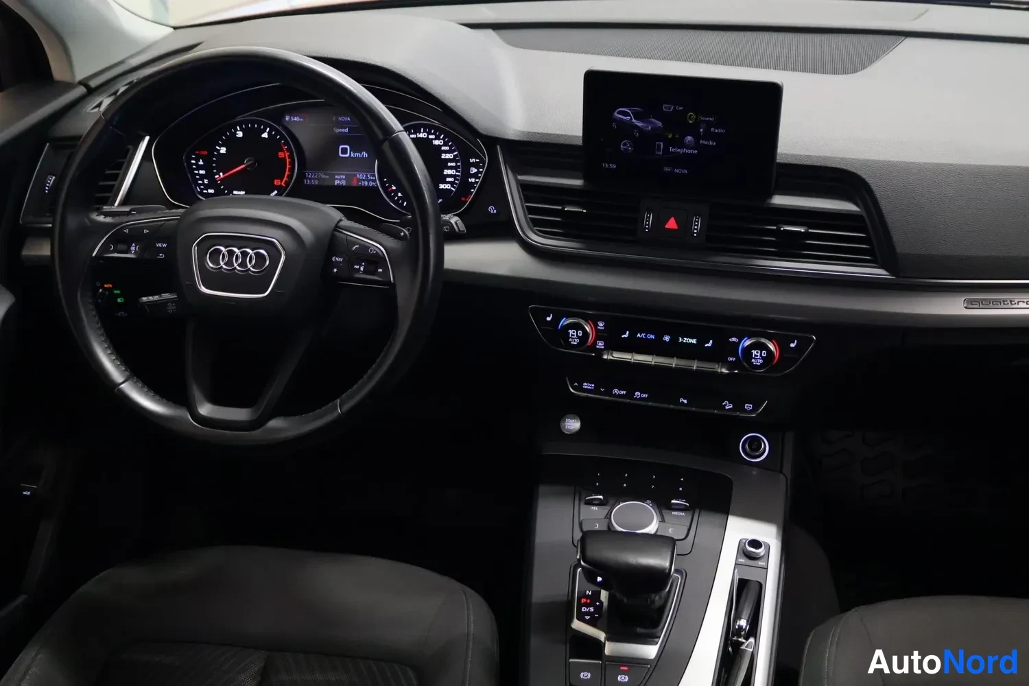 Muu: Ohjaamon näkymä: Audi-ohjauspyörä, mittaristo, kaistapitopaneeli, ilmastointipaneeli ja automaattivaihteen valitsin.